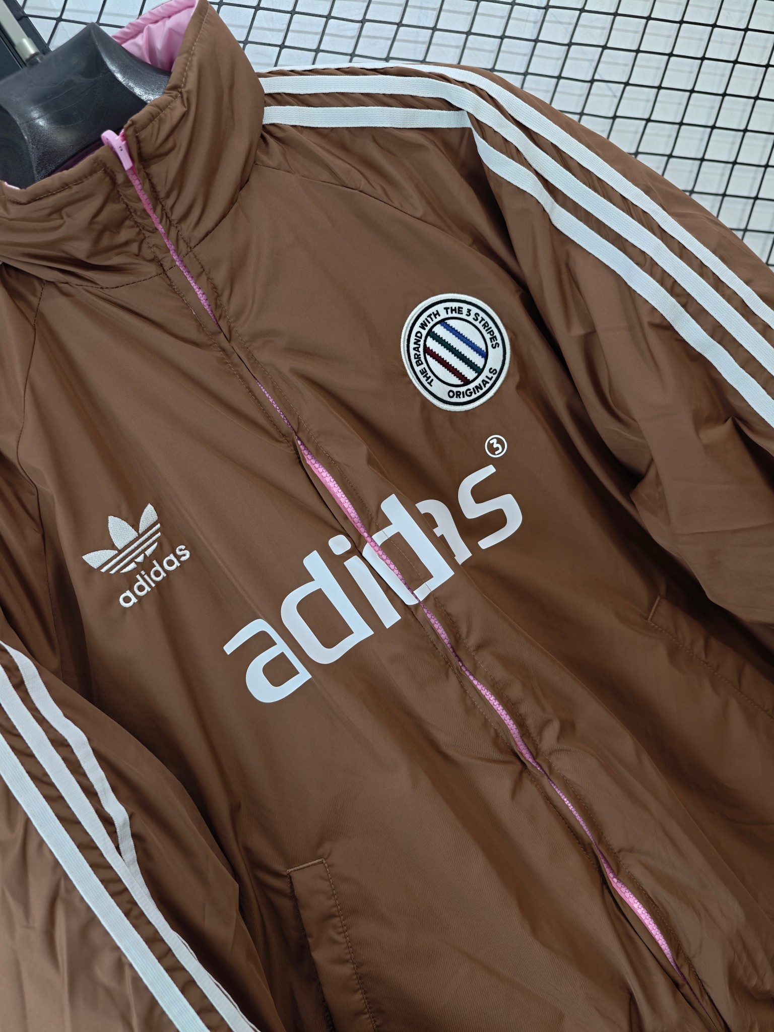💰185
【Adidas Originals | ADCREV PAD TT】
复古双面穿棉服· 条纹Logo · 宽松版型

● 核心工艺：采用双面可穿设计，实现一衣多穿的功能性；衣身饰有经典条纹Logo，延续品牌复古运动基因。
●甄选材质：面料注重保暖性与舒适度，内部填充提供良好保暖效果；细节处配备全套原版辅料，确保品质。
●包容版型：宽松剪裁，男女同款，适配多种身形，打造慵懒复古的街头风格。

尺码参考
M/ L / XL / XXL
（建议补充具体尺码数据，例如以厘米为单位的衣长、胸围等，以供参考）

配色
深棕粉色

#AdidasOriginals #双面穿棉服 #复古运动 #男女同款