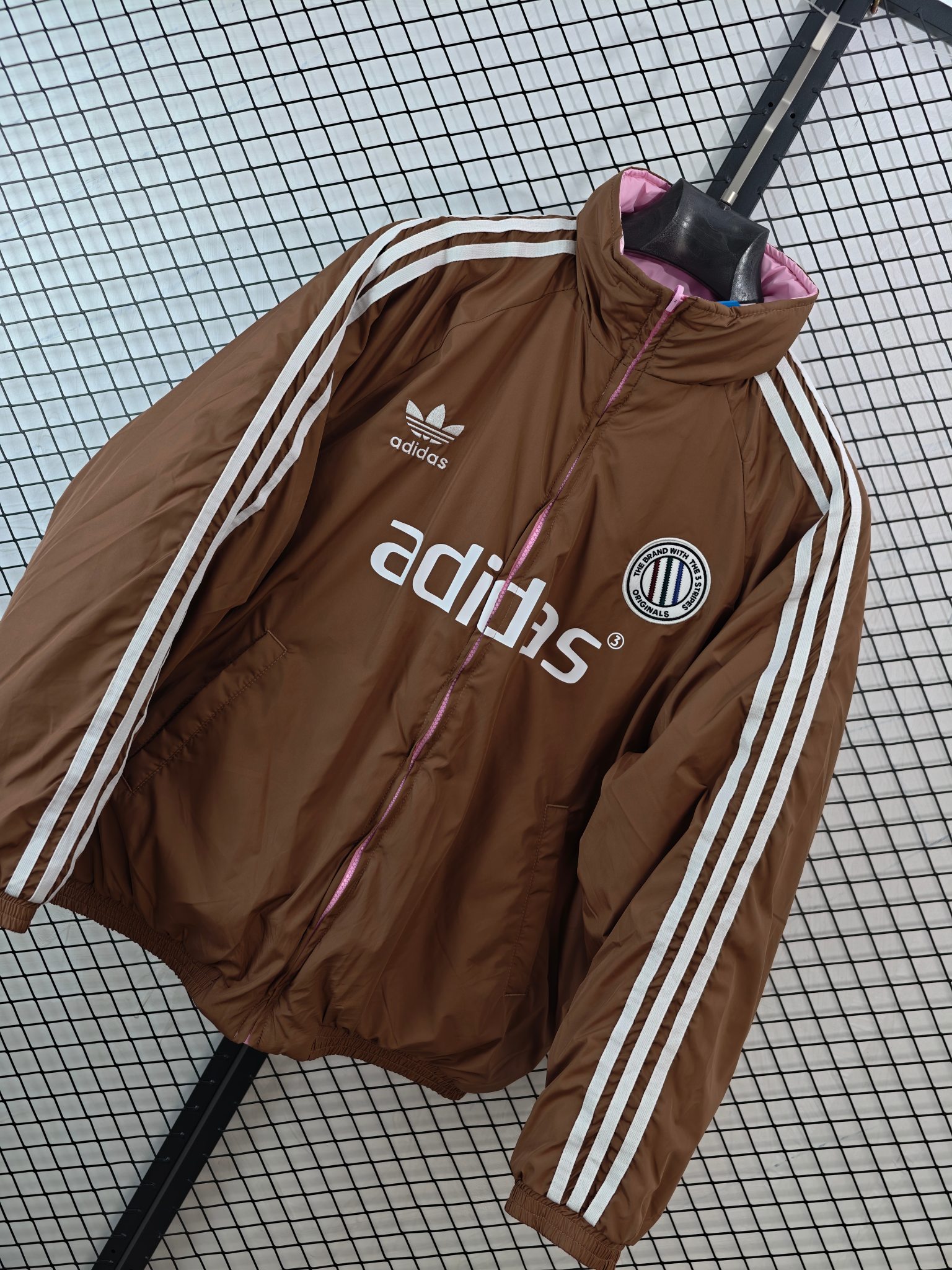 💰185
【Adidas Originals | ADCREV PAD TT】
复古双面穿棉服· 条纹Logo · 宽松版型

● 核心工艺：采用双面可穿设计，实现一衣多穿的功能性；衣身饰有经典条纹Logo，延续品牌复古运动基因。
●甄选材质：面料注重保暖性与舒适度，内部填充提供良好保暖效果；细节处配备全套原版辅料，确保品质。
●包容版型：宽松剪裁，男女同款，适配多种身形，打造慵懒复古的街头风格。

尺码参考
M/ L / XL / XXL
（建议补充具体尺码数据，例如以厘米为单位的衣长、胸围等，以供参考）

配色
深棕粉色

#AdidasOriginals #双面穿棉服 #复古运动 #男女同款