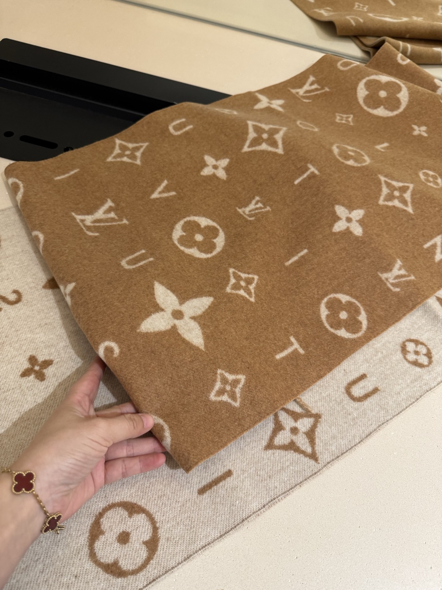 PReykjavik 2.0 围巾为柔软山羊绒标注 Monogram 花卉和 LV 字母，其间点缀品牌名