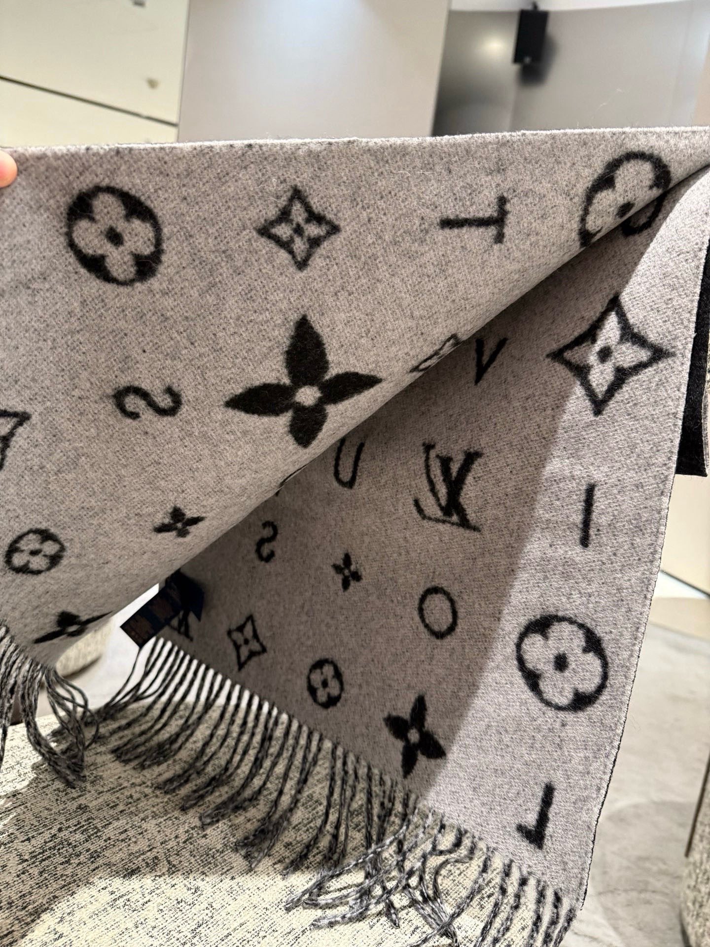 PReykjavik 2.0 围巾为柔软山羊绒标注 Monogram 花卉和 LV 字母，其间点缀品牌名