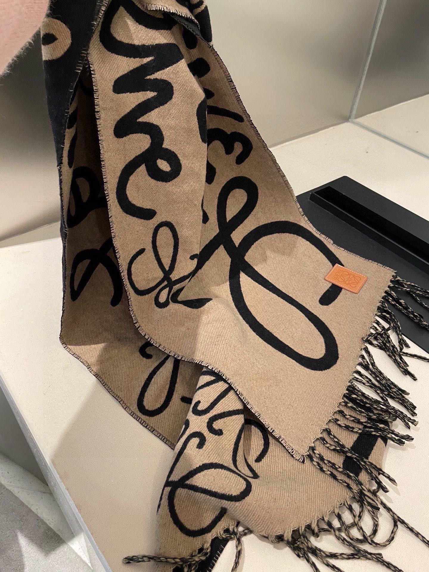 P爆款上牛货【LW拼色羊绒长巾】🧶 LOEWE 2025早秋系列释出新款字母涂鸦风围巾，两端带有流苏，饰