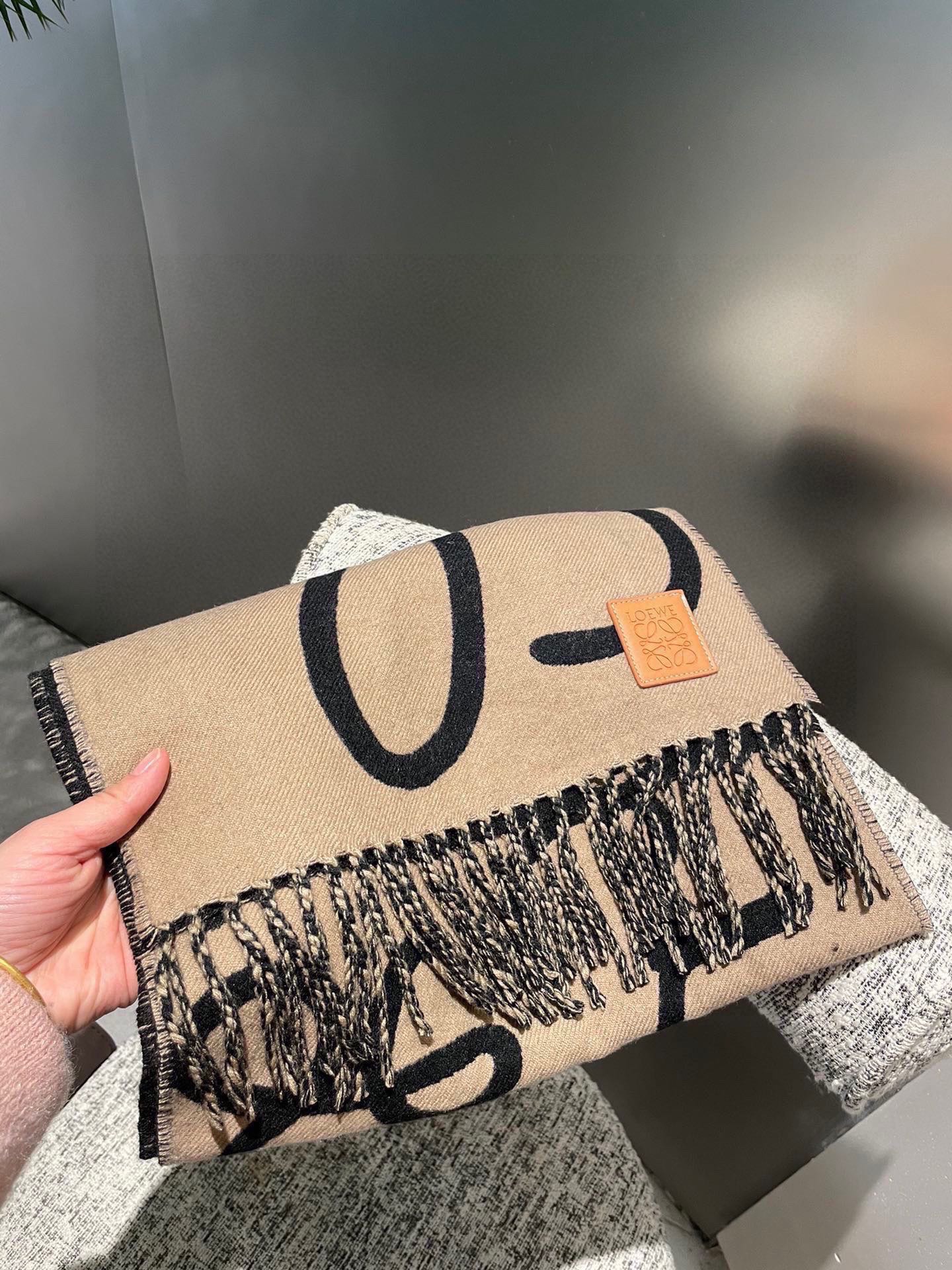 P爆款上牛货【LW拼色羊绒长巾】🧶 LOEWE 2025早秋系列释出新款字母涂鸦风围巾，两端带有流苏，饰