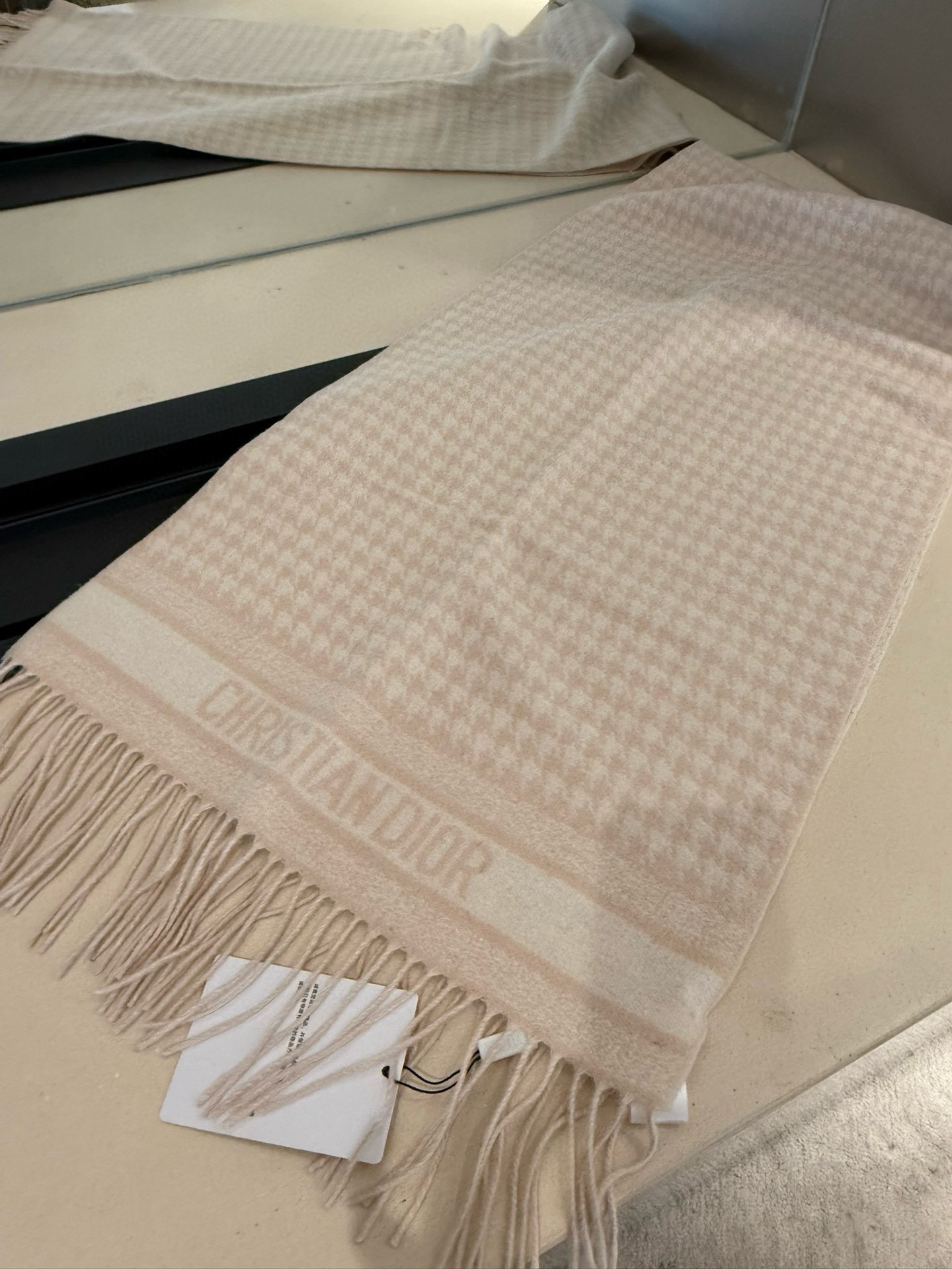 PDior25新款千鸟格围巾，这款围巾向经典的粉色和白色千鸟格纹图案致敬。采用羊绒面料精心制作，双面设计