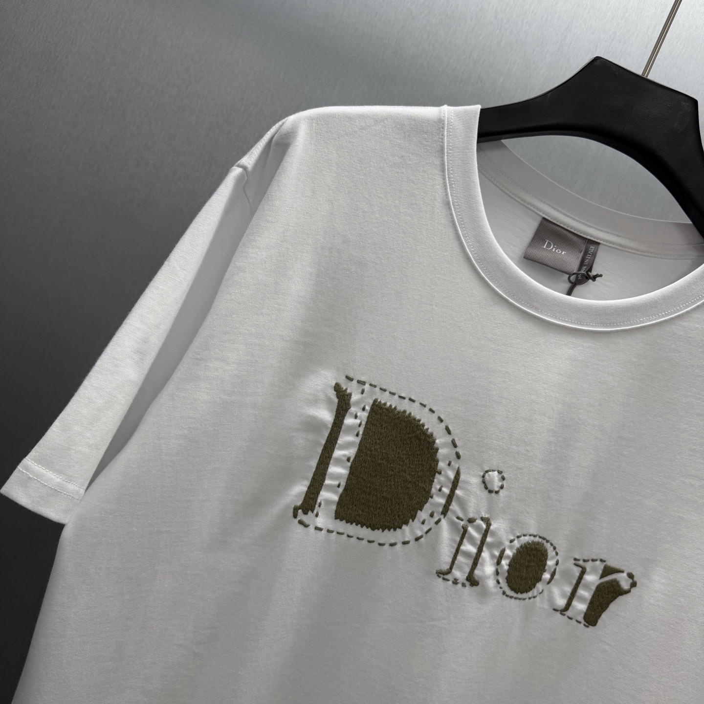 Dior 这款T恤是二零二六夏季男装系列新品 是展现 Dior精湛工艺的典范之作 采用黑色棉质平纹针织面料精心制作