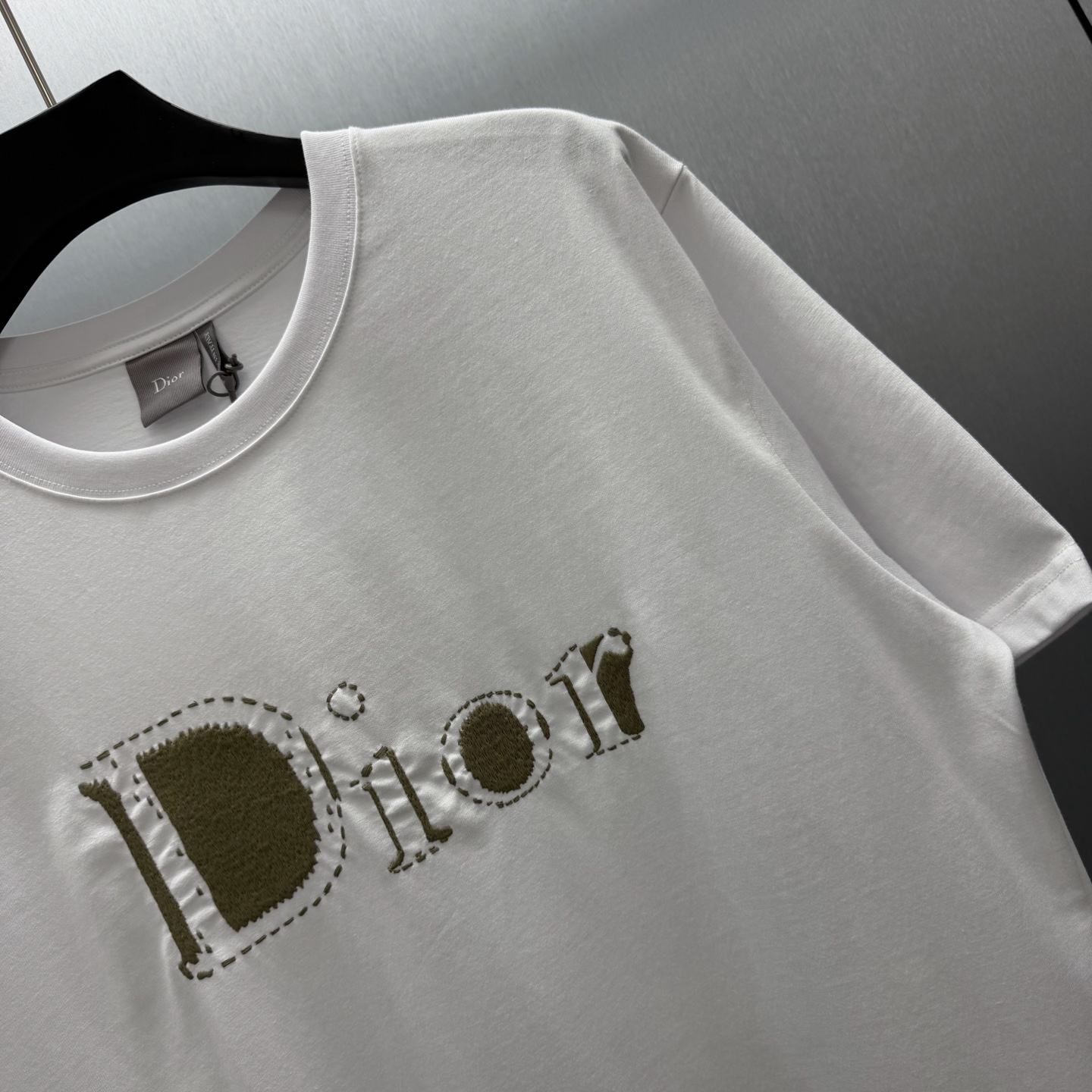 Dior 这款T恤是二零二六夏季男装系列新品 是展现 Dior精湛工艺的典范之作 采用黑色棉质平纹针织面料精心制作