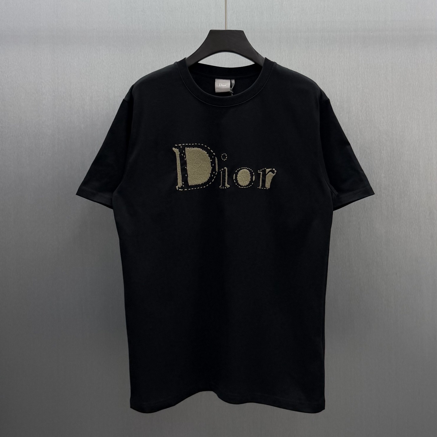 Dior 这款T恤是二零二六夏季男装系列新品 是展现 Dior精湛工艺的典范之作 采用黑色棉质平纹针织面料精心制作