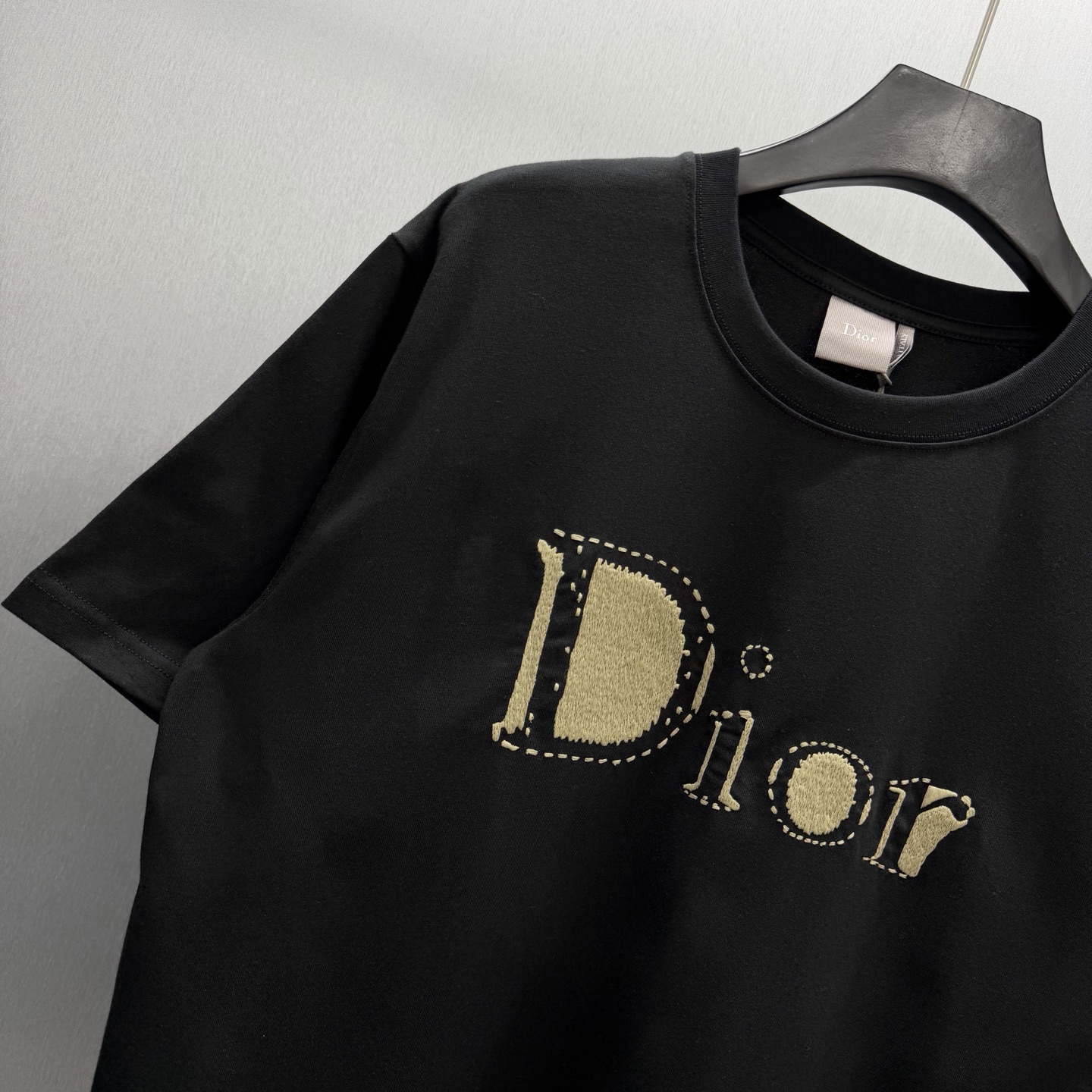 Dior 这款T恤是二零二六夏季男装系列新品 是展现 Dior精湛工艺的典范之作 采用黑色棉质平纹针织面料精心制作