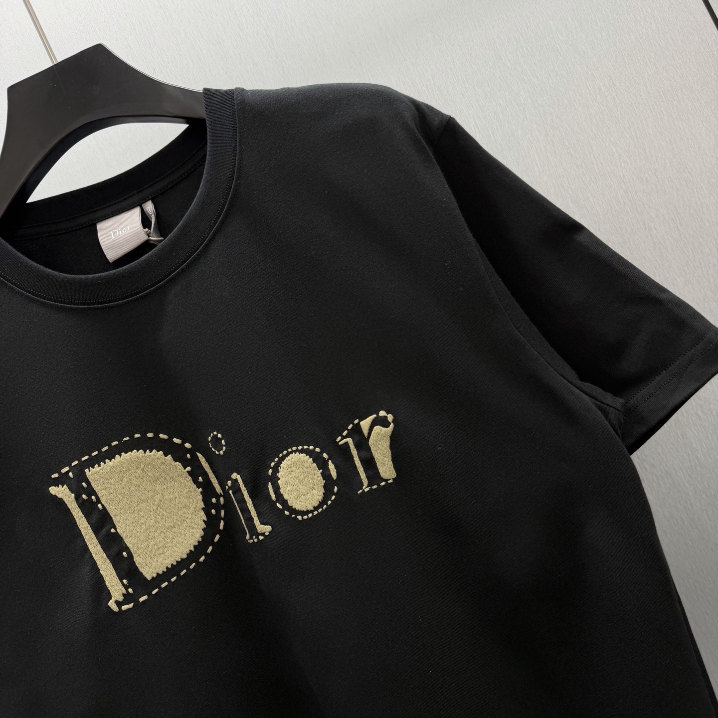 Dior 这款T恤是二零二六夏季男装系列新品 是展现 Dior精湛工艺的典范之作 采用黑色棉质平纹针织面料精心制作