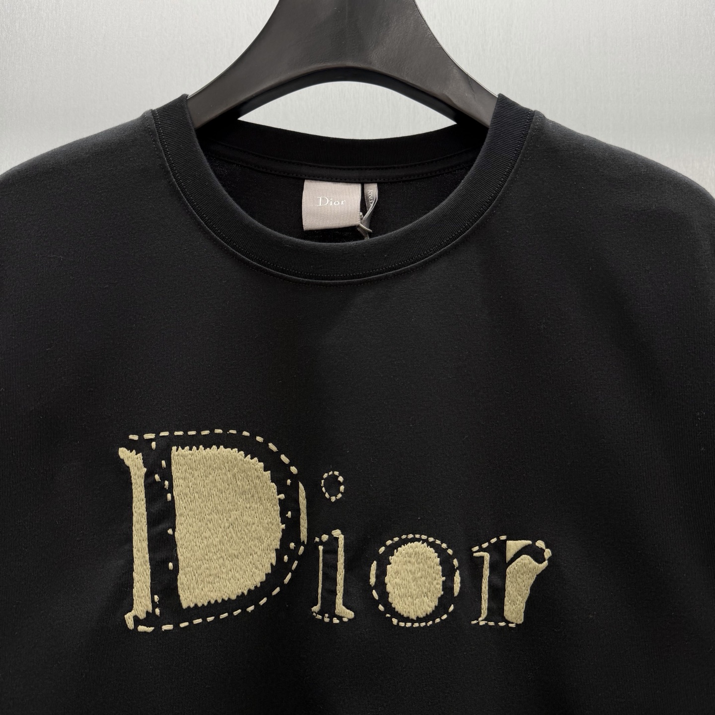 Dior 这款T恤是二零二六夏季男装系列新品 是展现 Dior精湛工艺的典范之作 采用黑色棉质平纹针织面料精心制作
