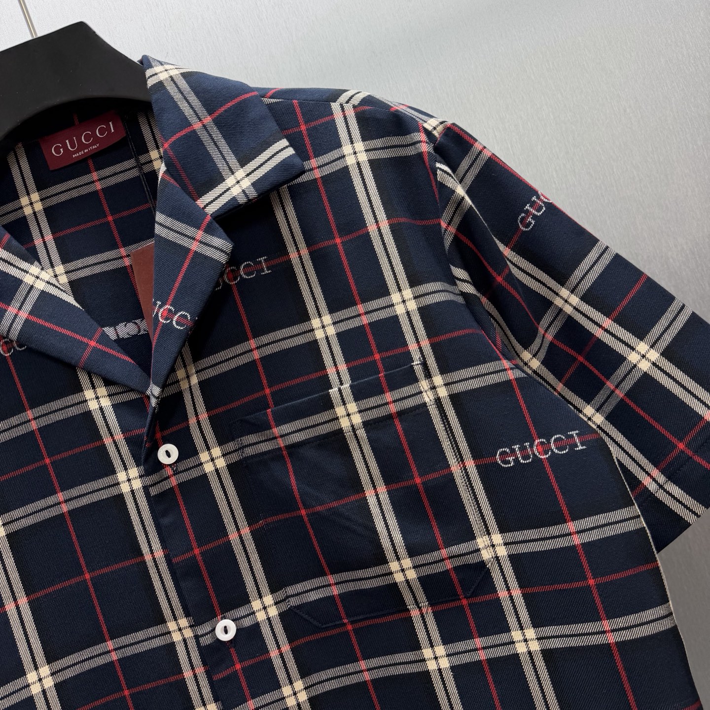 Gucci 藏青底色交织米白+红色格纹 又不失活力的撞色 满幅“GUCCI”刺绣让品牌感藏在细节里~ 短袖翻领设计