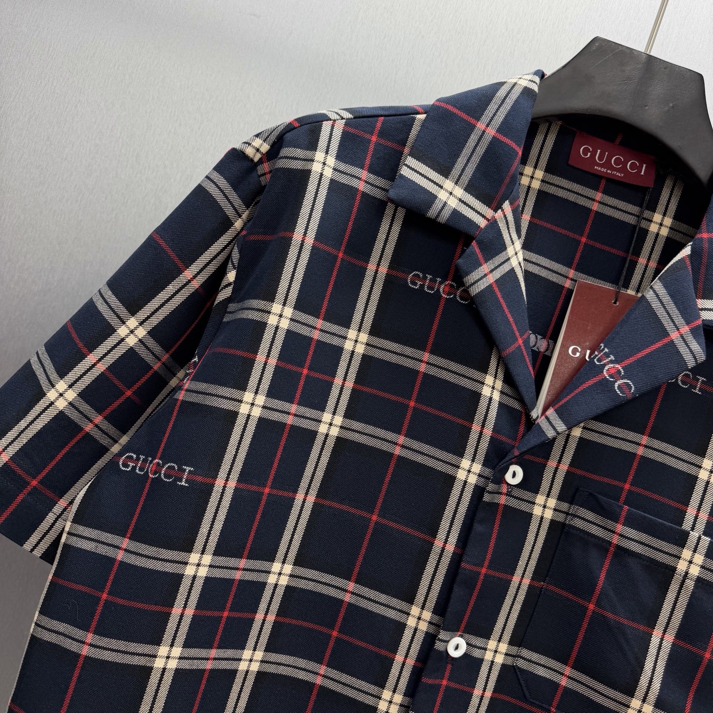 Gucci 藏青底色交织米白+红色格纹 又不失活力的撞色 满幅“GUCCI”刺绣让品牌感藏在细节里~ 短袖翻领设计