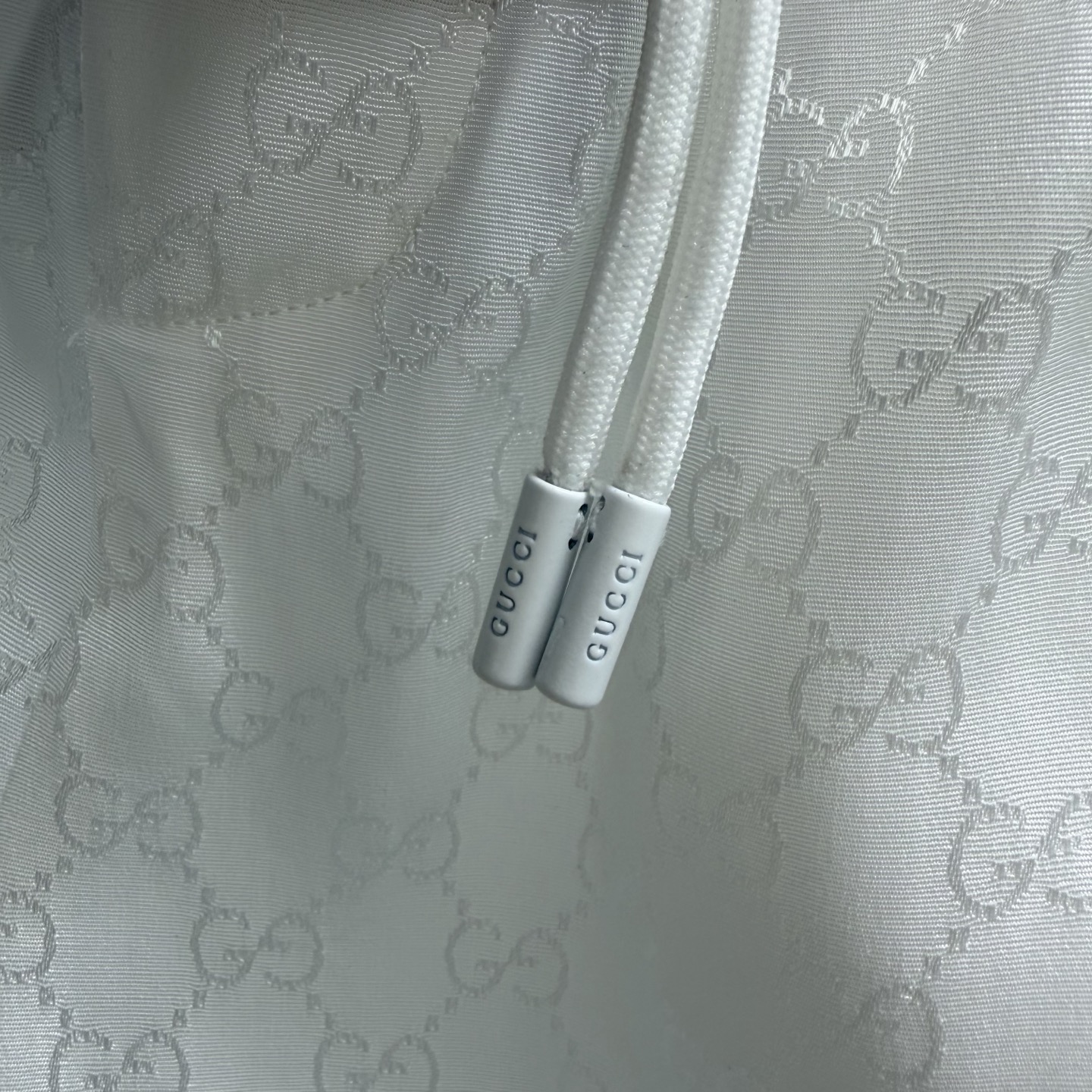 Gucci 白色 GG 提花短裤，以细腻提花工艺织就 双 G 纹理，光泽感面料自带高级氛围。抽绳腰头+金属拉链口袋，兼顾舒适与酷感