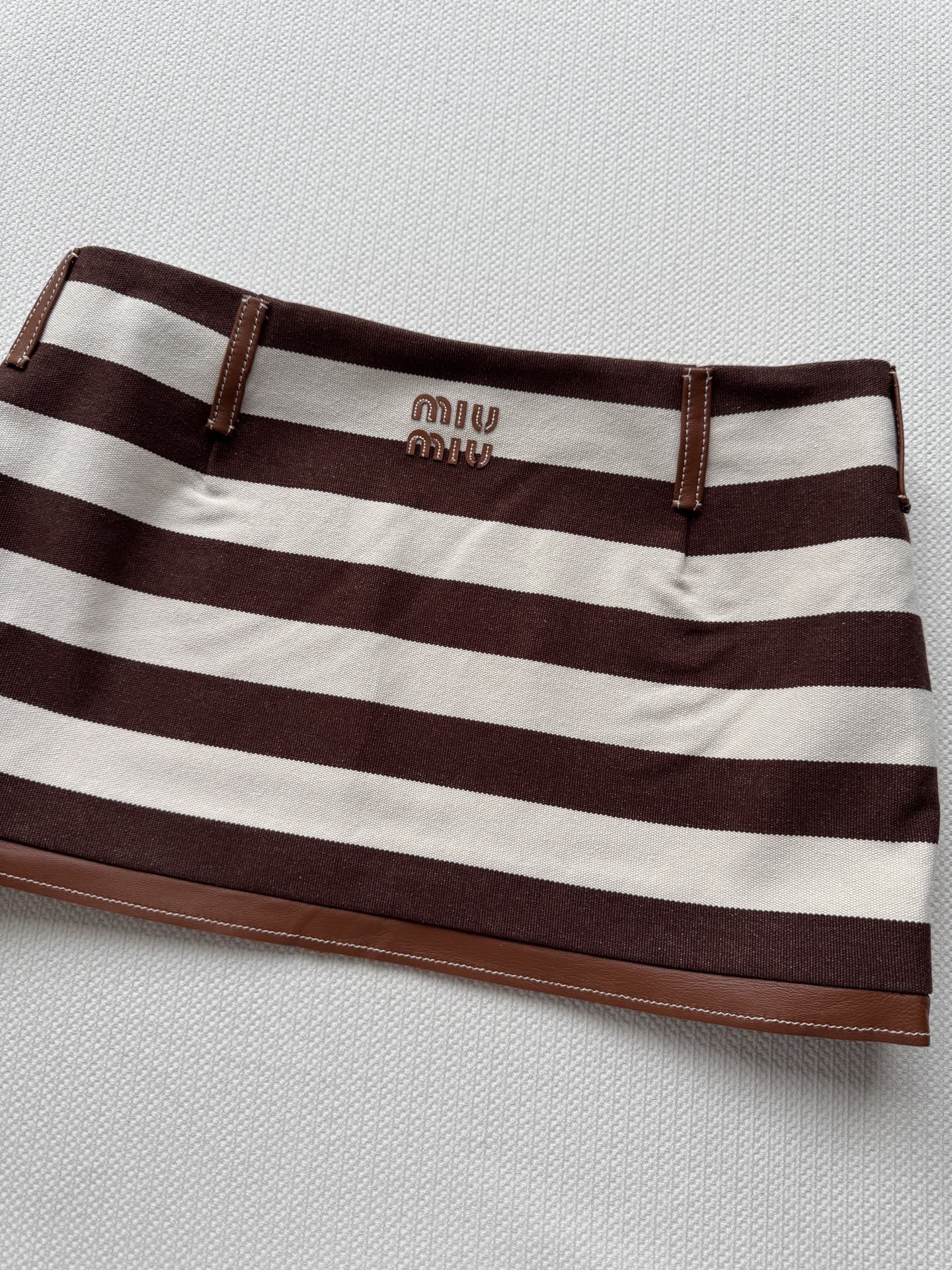 miumi*🆕新款， 拼皮间色条纹辣妹短裙🤎❤️🤍千禧复古ootd也能轻松驾驭！低腰短裙版型上身拉长比例