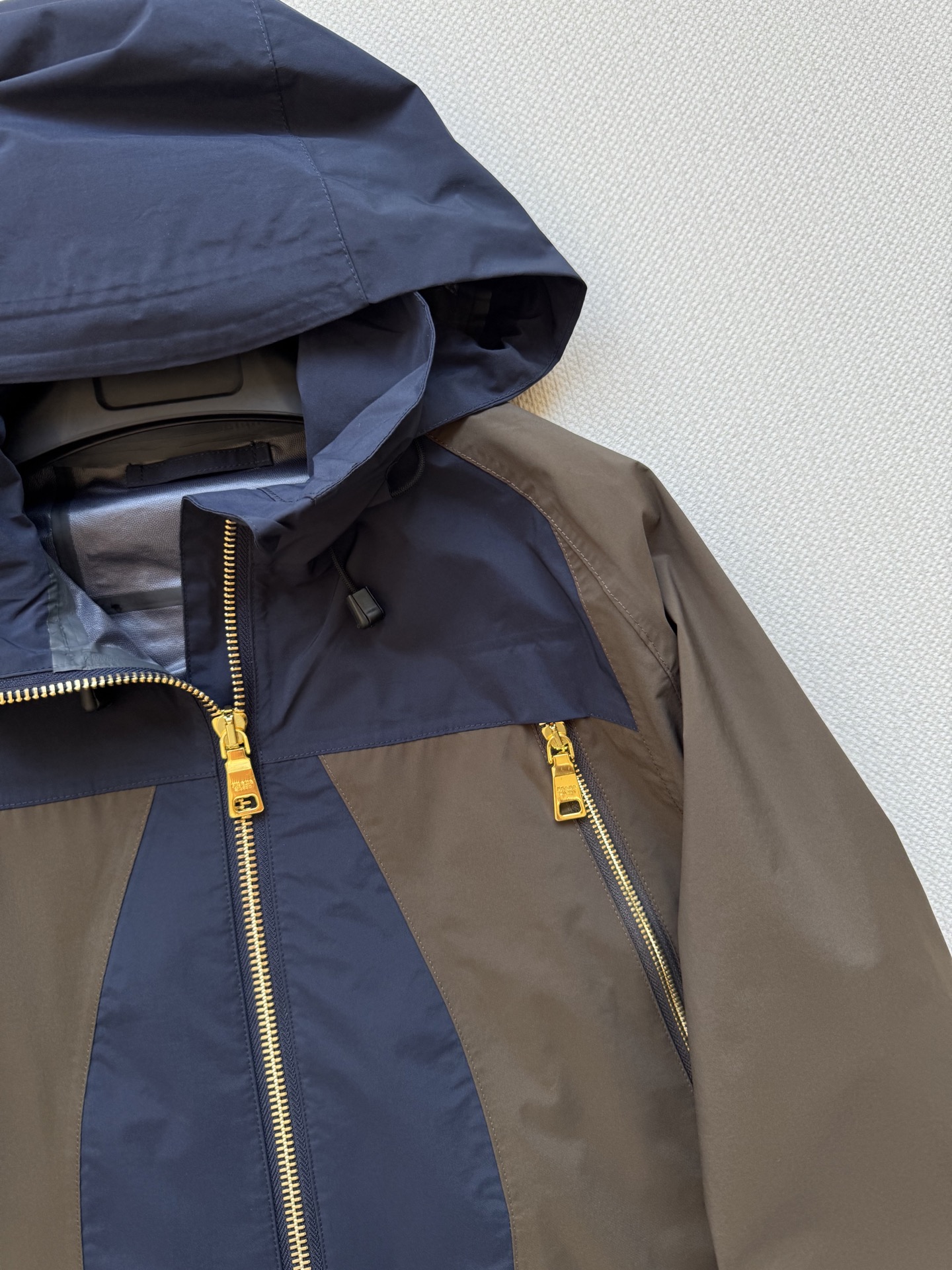 Prad*🆕2025SS早秋新款 撞色连帽冲锋外套 这款外套的配色设计超有巧思，棕色与深蓝色的拼接，就像