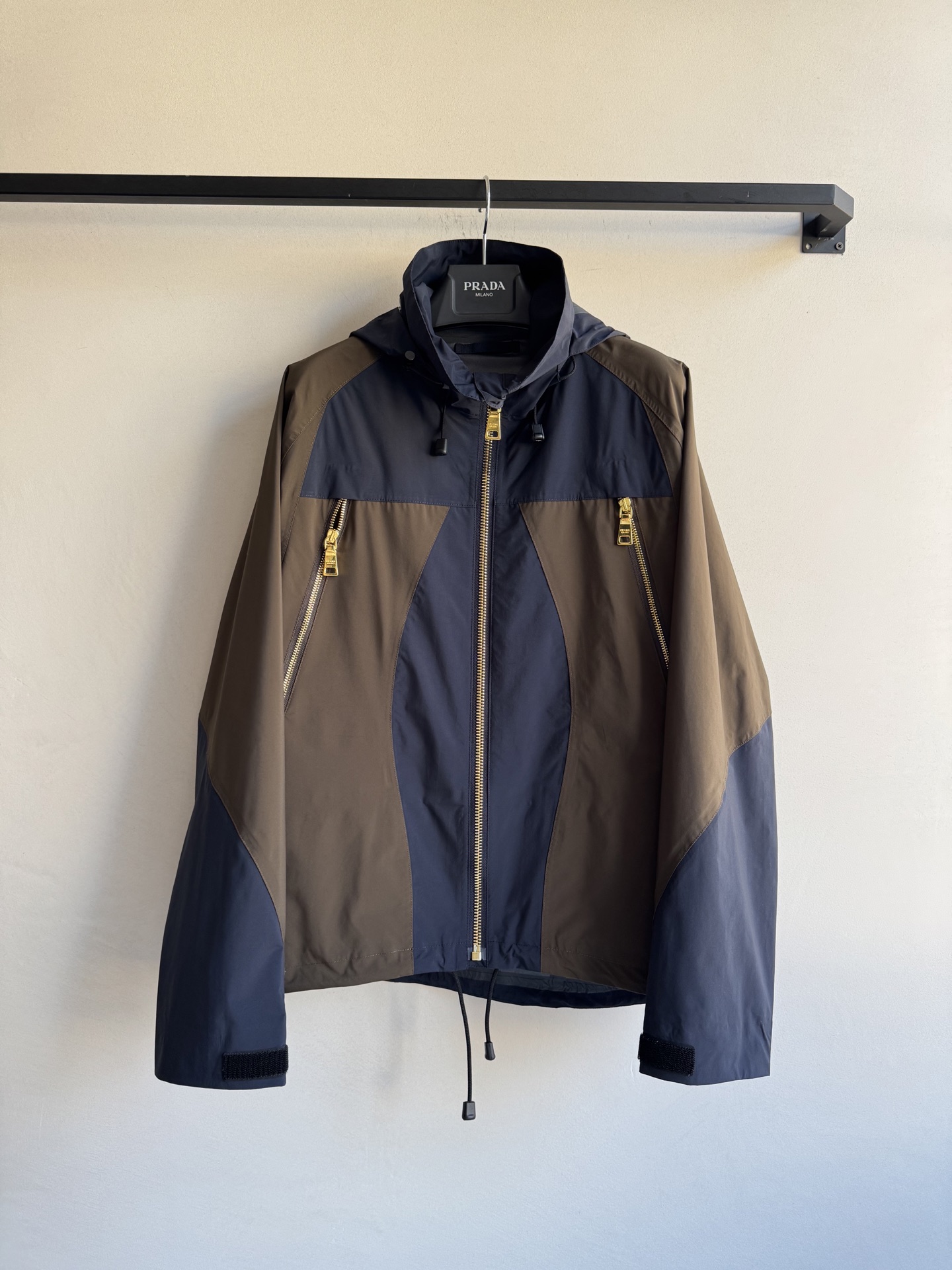 Prad*🆕2025SS早秋新款 撞色连帽冲锋外套 这款外套的配色设计超有巧思，棕色与深蓝色的拼接，就像