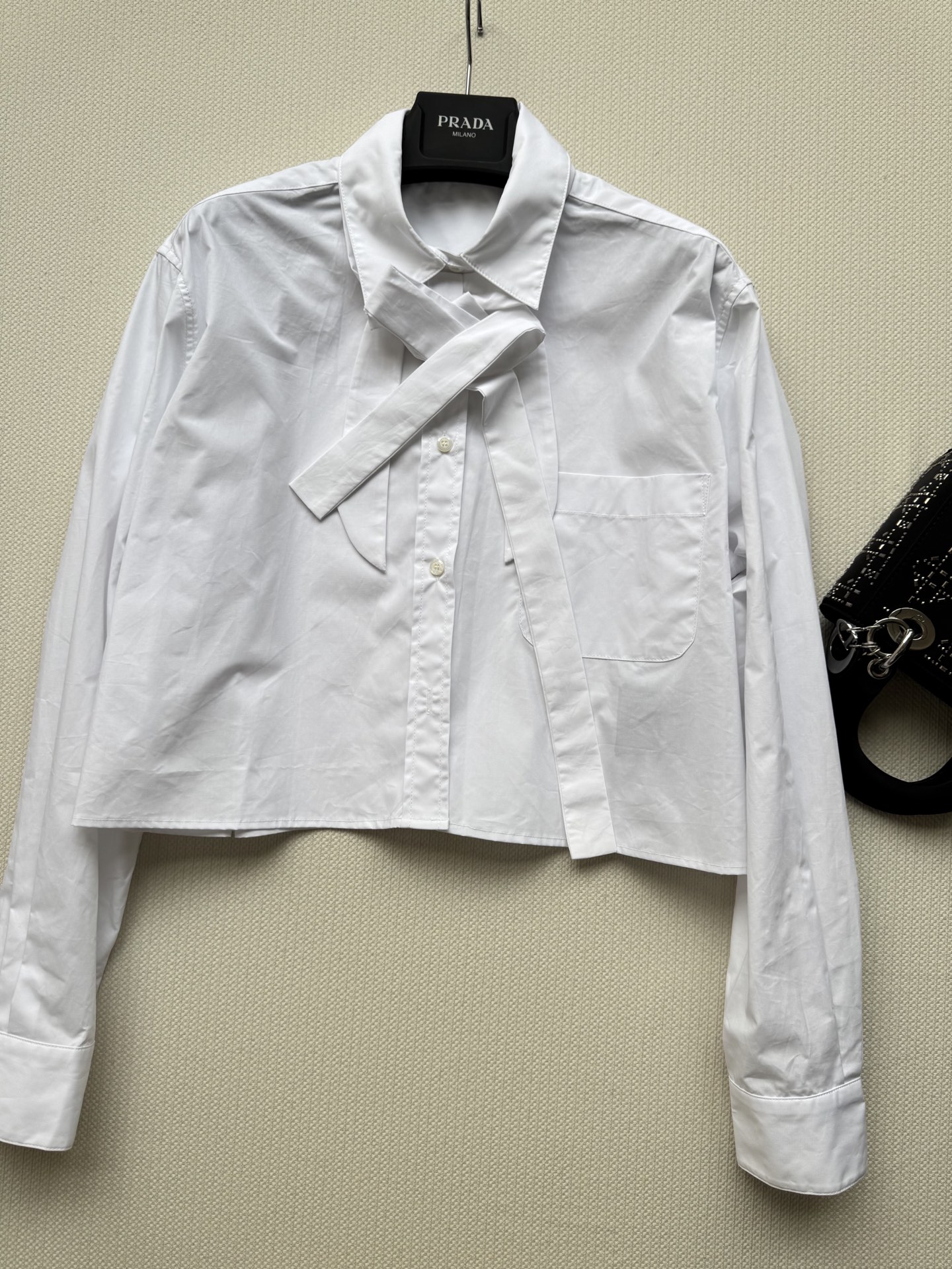 Prad*🆕25秋冬新款 短款蝴蝶结衬衫 后背有经典品牌倒三角标识,衬衣真的是衣柜必不可少的单品！宽松版