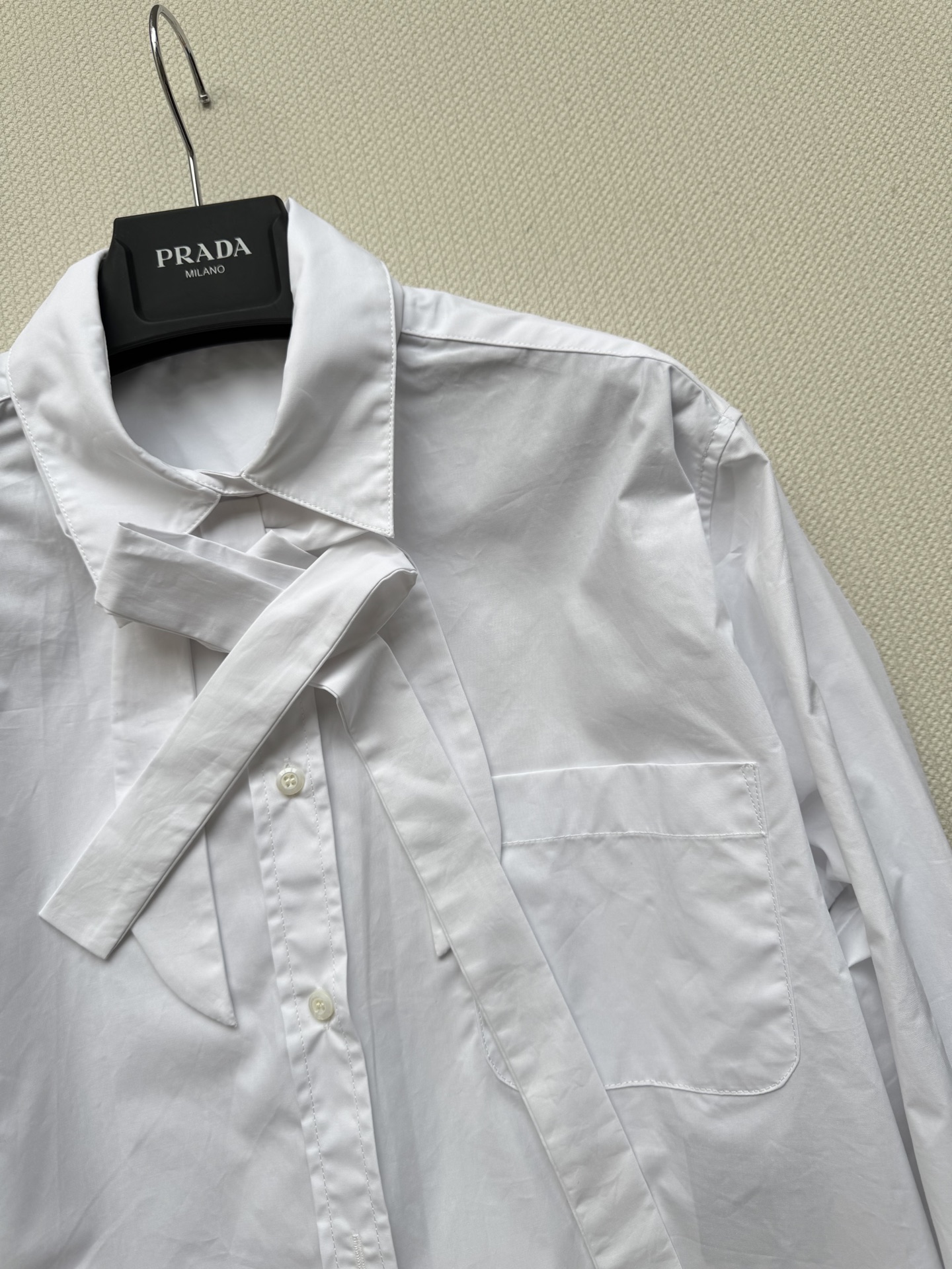 Prad*🆕25秋冬新款 短款蝴蝶结衬衫 后背有经典品牌倒三角标识,衬衣真的是衣柜必不可少的单品！宽松版