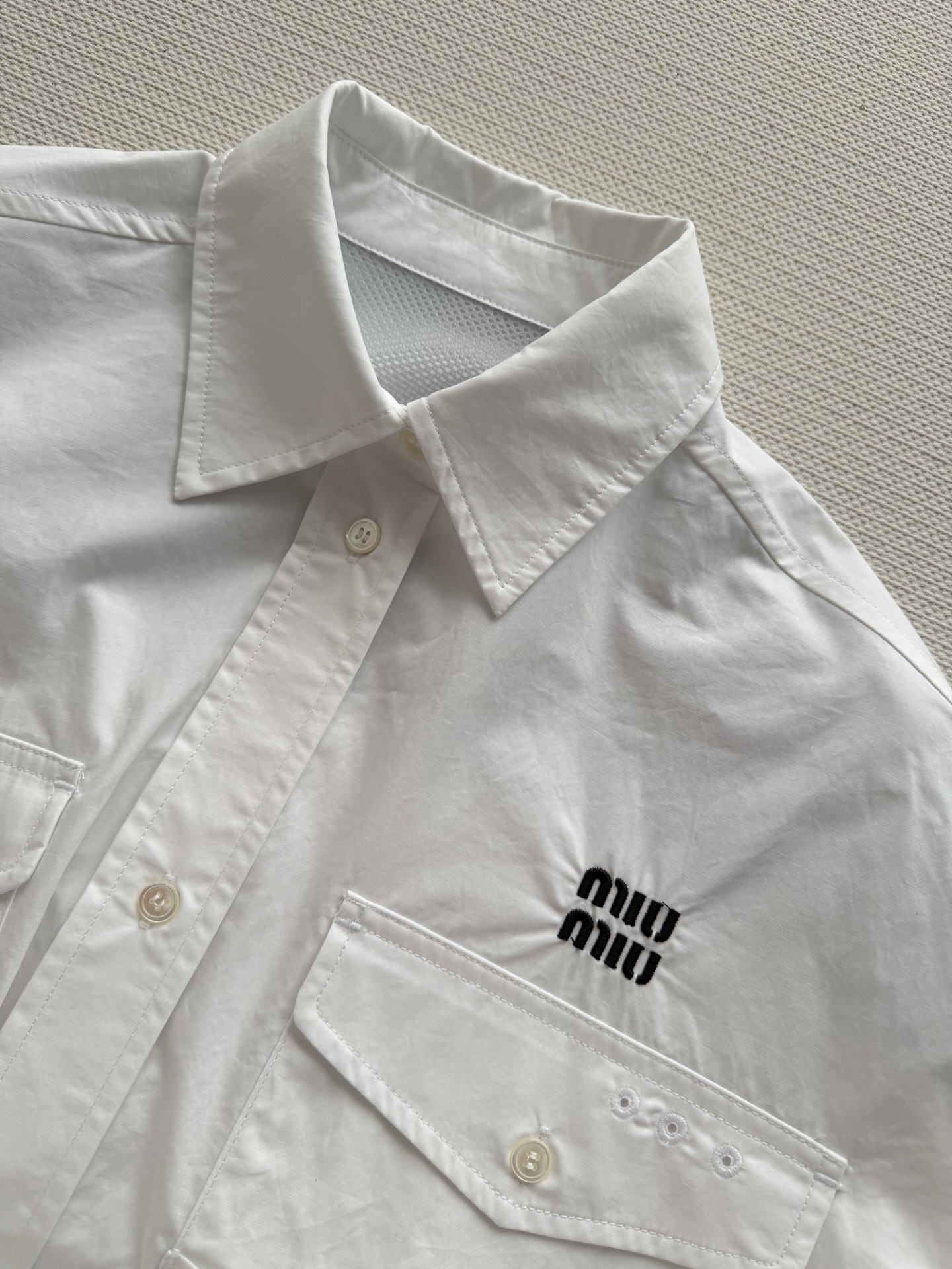 MiuMi*🆕这款白色工装风衬衫，采用全棉材质，挺括有型，胸前双口袋+袖口抽绳设计，机能感满满✨。左胸“