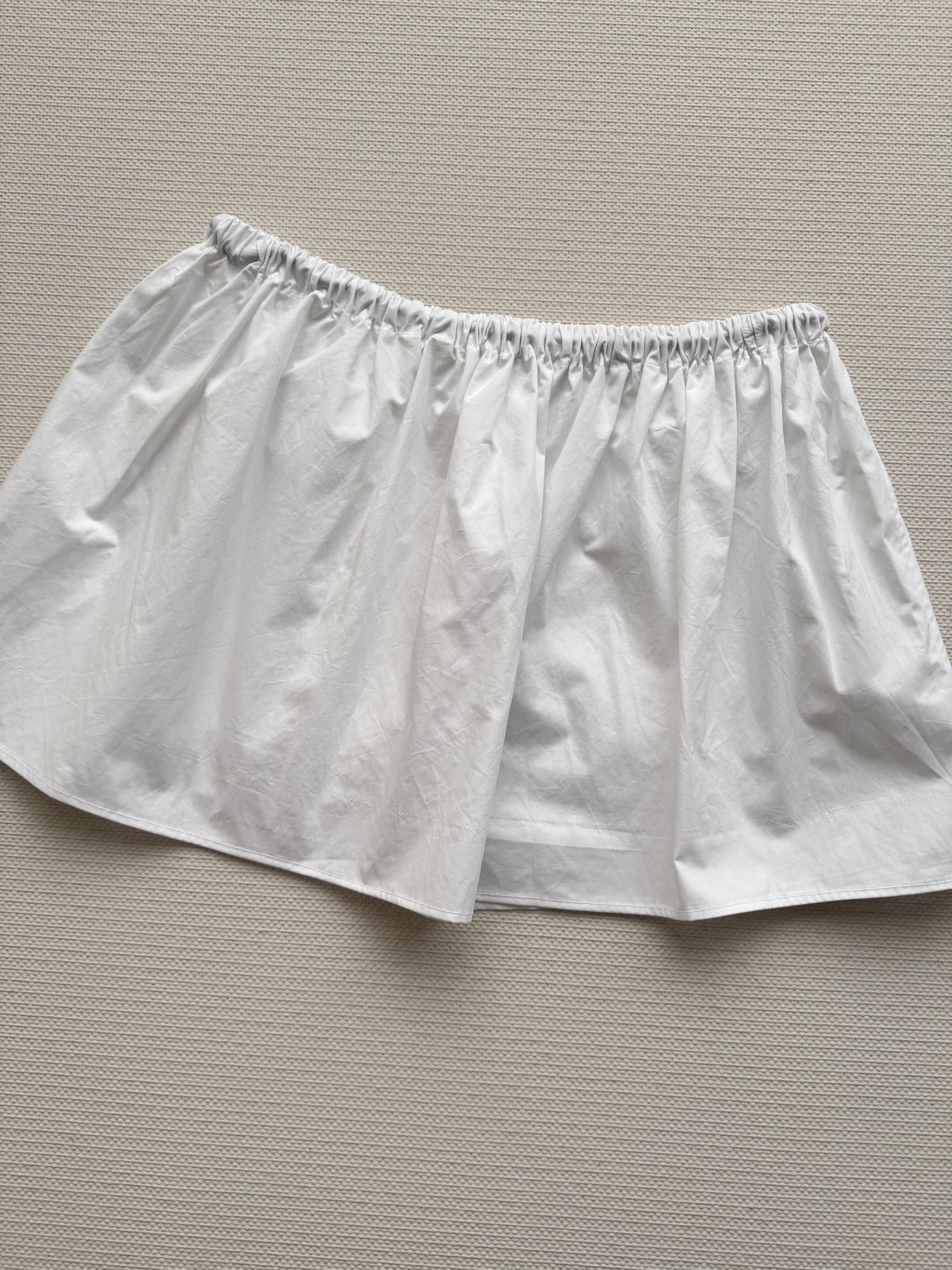 Miu Mi*🆕这款白色工装半裙，采用轻薄科技府绸，触感柔软又挺括。A字版型+松紧腰，舒适显瘦，适合多种