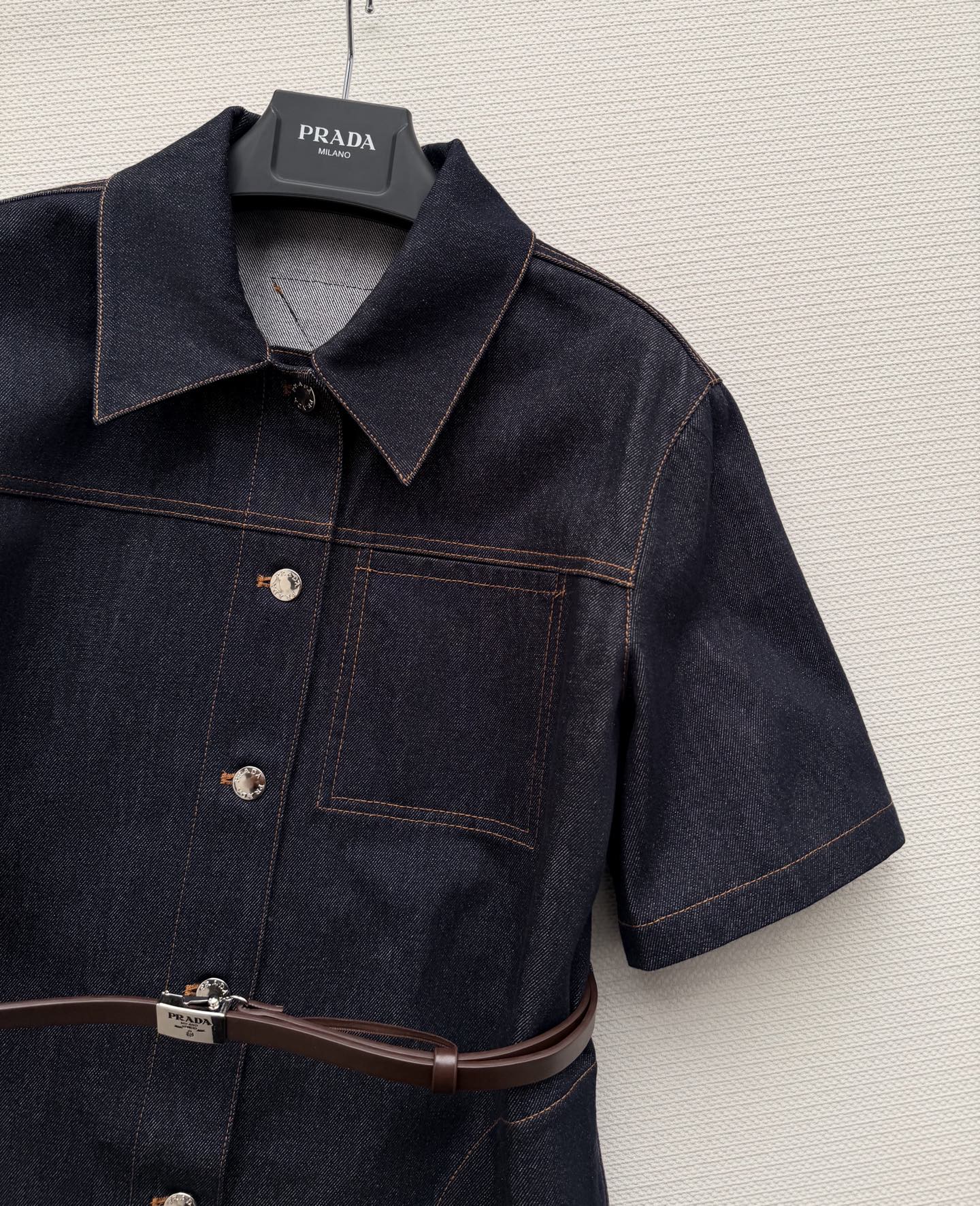 PRAD*🆕这款深色牛仔连衣裙，经典衬衫式设计，短袖+单排扣，简约又有细节感✨。腰部可调节腰带，轻松勾勒