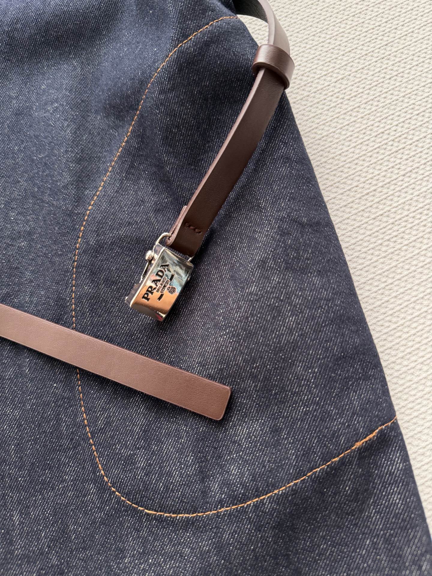 PRAD*🆕这款深色牛仔连衣裙，经典衬衫式设计，短袖+单排扣，简约又有细节感✨。腰部可调节腰带，轻松勾勒