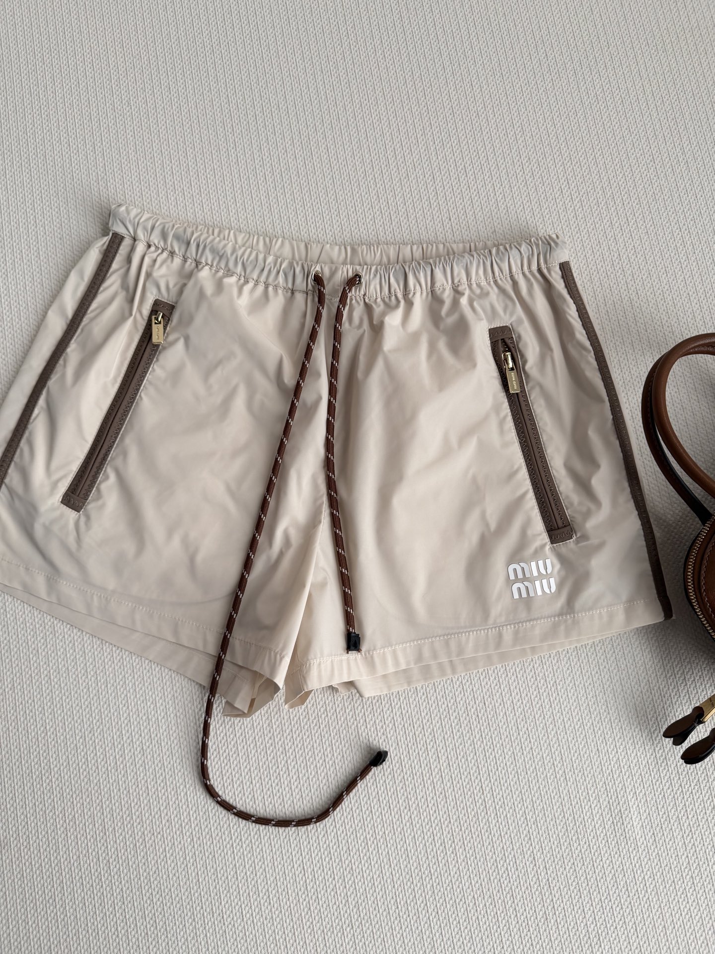 Miumi*🆕26全新最新短裤定制YB环保再生尼龙材质，质感光泽，穿搭有型，弹力短裤，大身以杏色为基底，