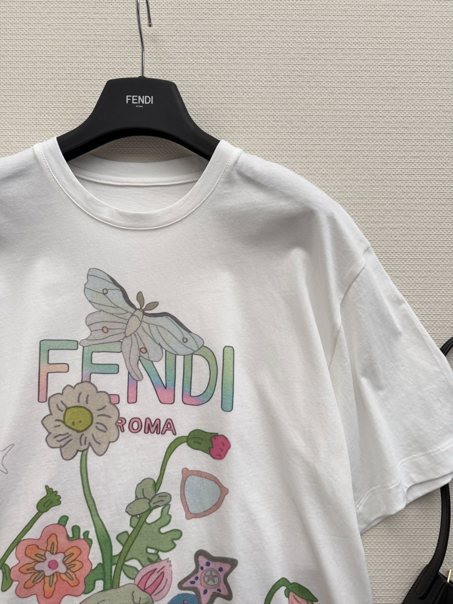 Fend*🆕这款多色印花短袖T恤，白色棉质面料，正面有花卉、蝴蝶和星星等童趣元素，色彩超亮眼✨。胸前“F