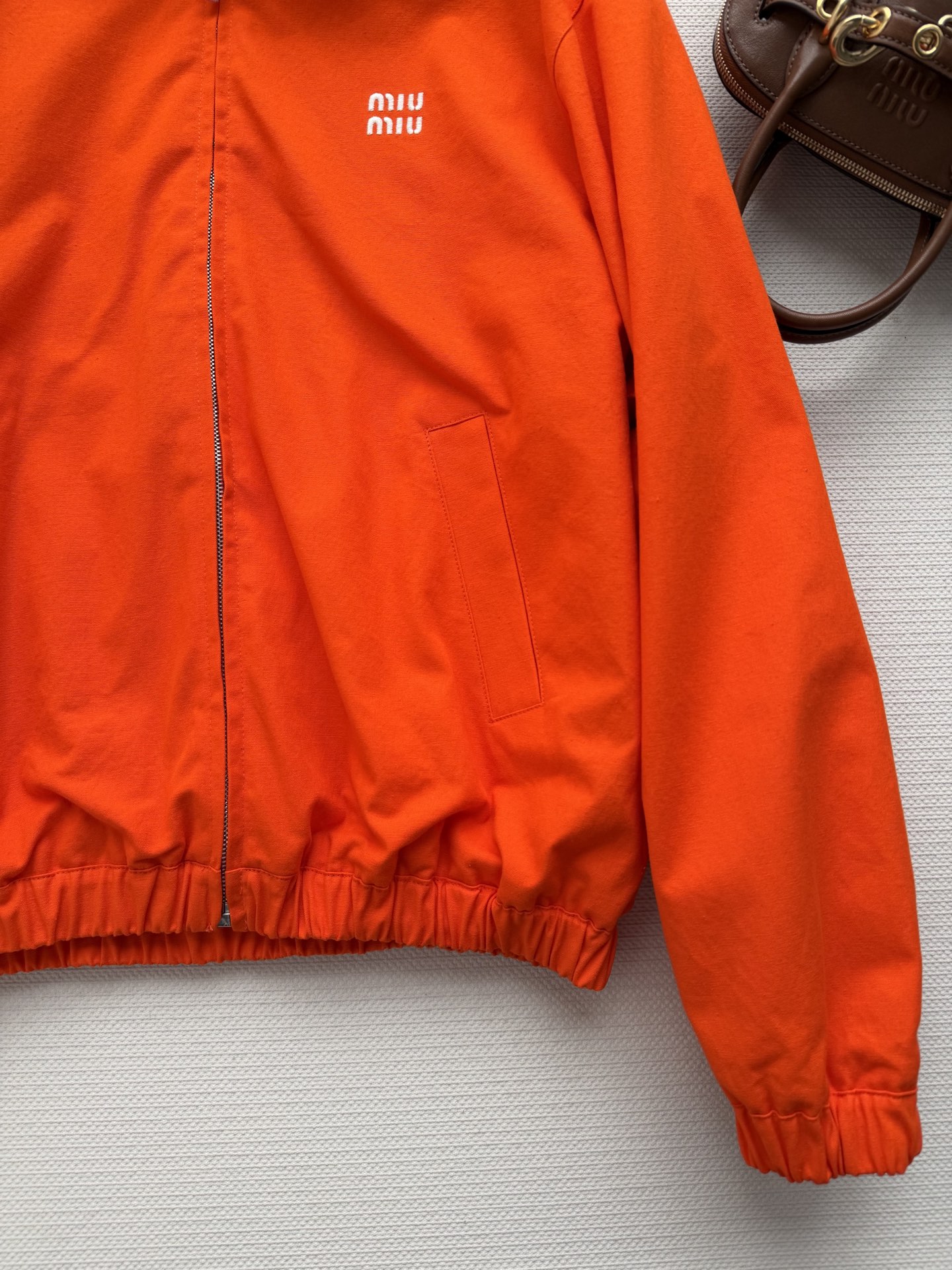 Miu Mi*🆕2026春夏系列橙色拉链夹克，轻便面料+束腰设计，简约又时髦！正面品牌徽标超有辨识度，内