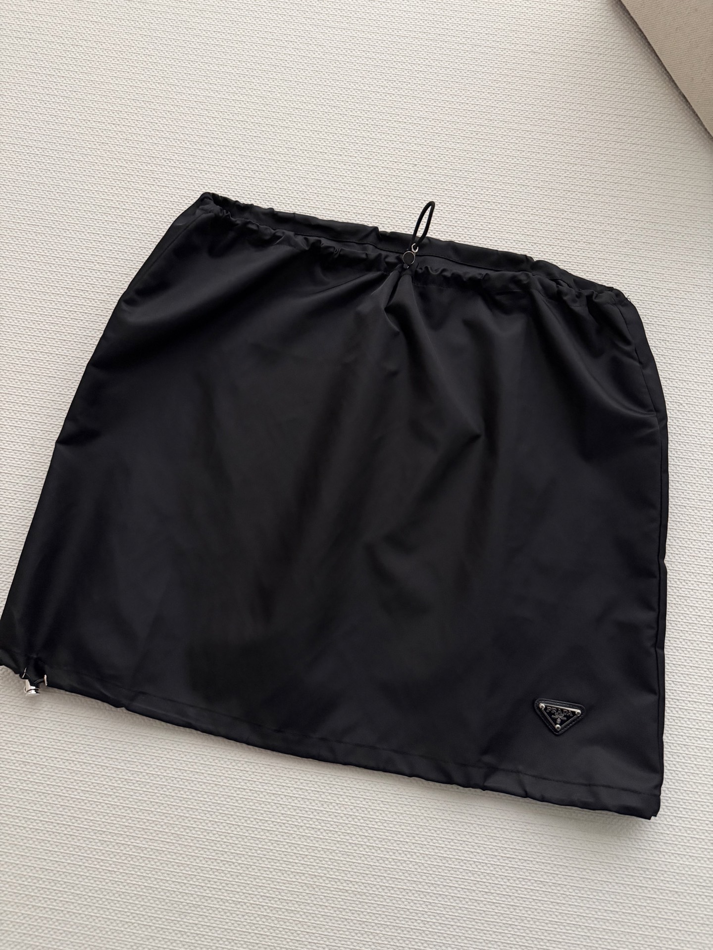 Prad*🆕新款，这款尼龙抽绳半裙，轻盈垂顺，黑色简约百搭，日常通勤或休闲都能轻松驾驭✨。抽绳设计超实用