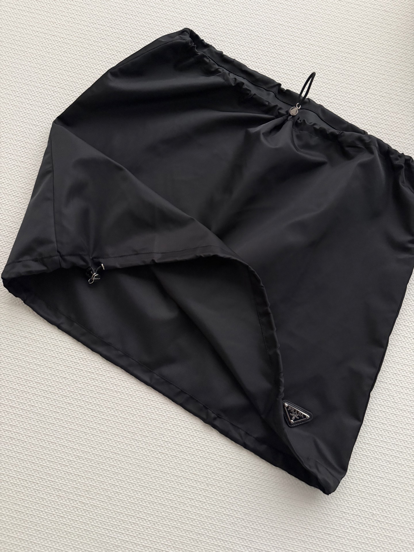 Prad*🆕新款，这款尼龙抽绳半裙，轻盈垂顺，黑色简约百搭，日常通勤或休闲都能轻松驾驭✨。抽绳设计超实用