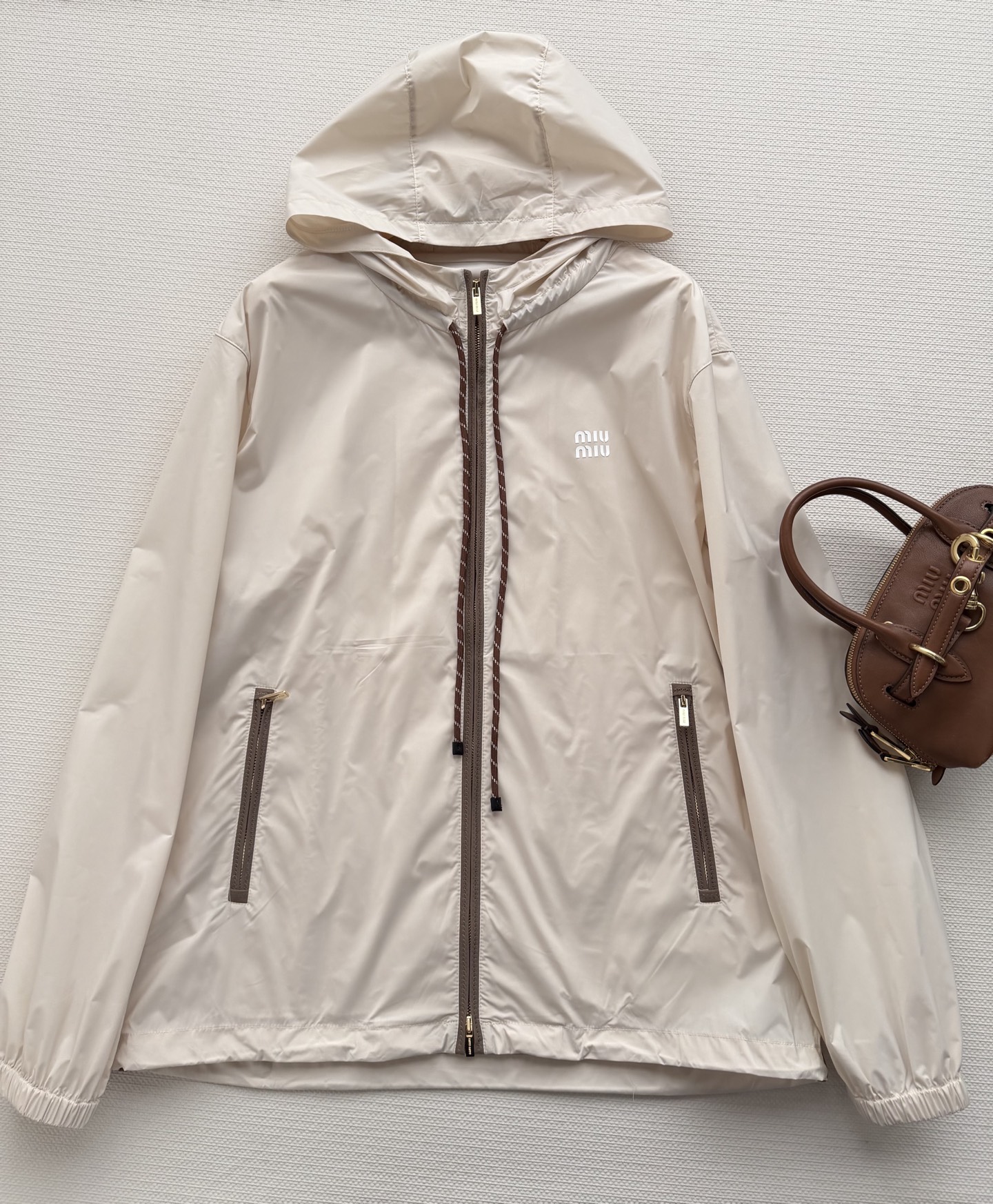 Miumi*🆕徽标字母宽松尼龙连帽外套 定制环保再生尼龙材质，质感自带丝绸光泽，穿搭有型，整体以素色为基