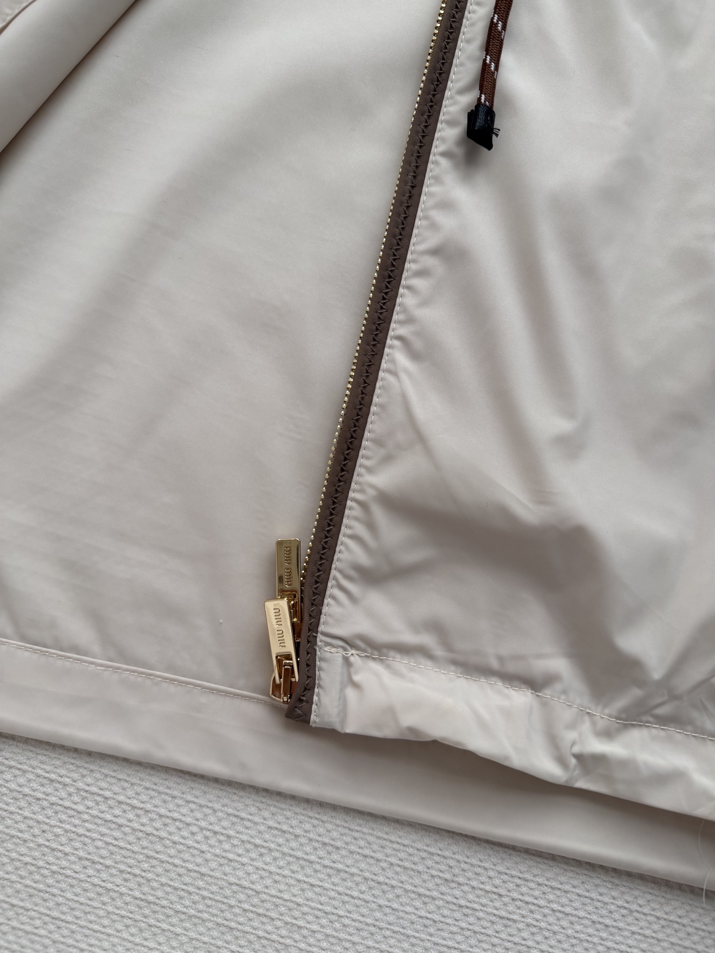 Miumi*🆕徽标字母宽松尼龙连帽外套 定制环保再生尼龙材质，质感自带丝绸光泽，穿搭有型，整体以素色为基