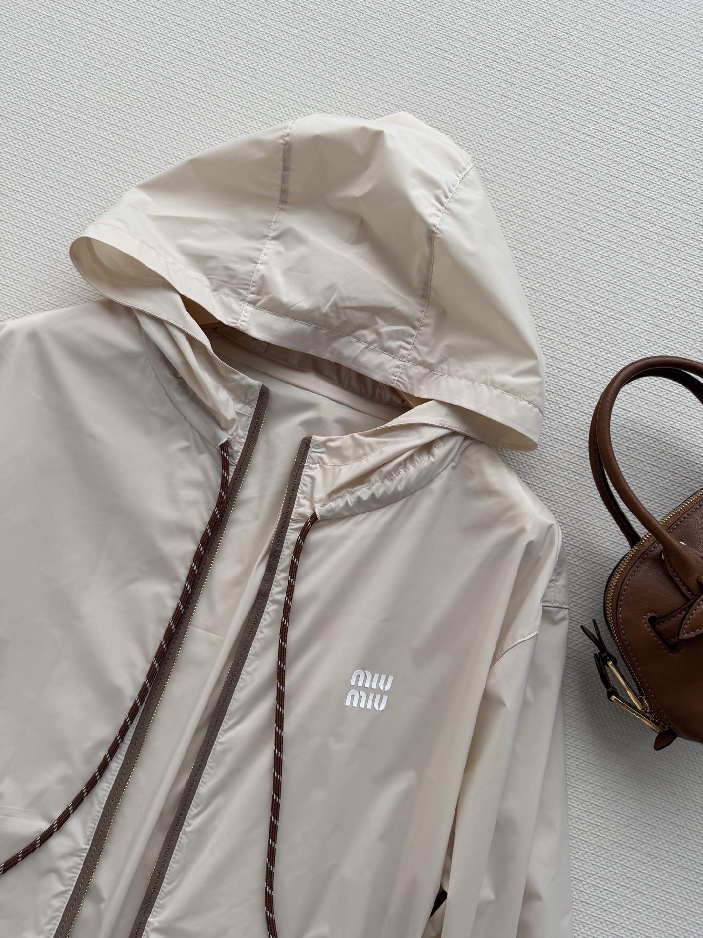 Miumi*🆕徽标字母宽松尼龙连帽外套 定制环保再生尼龙材质，质感自带丝绸光泽，穿搭有型，整体以素色为基