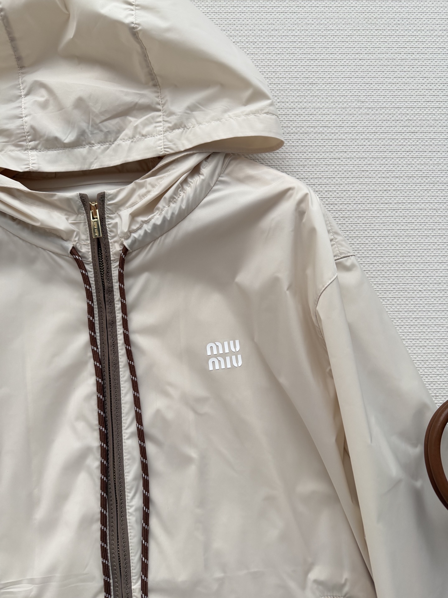Miumi*🆕徽标字母宽松尼龙连帽外套 定制环保再生尼龙材质，质感自带丝绸光泽，穿搭有型，整体以素色为基