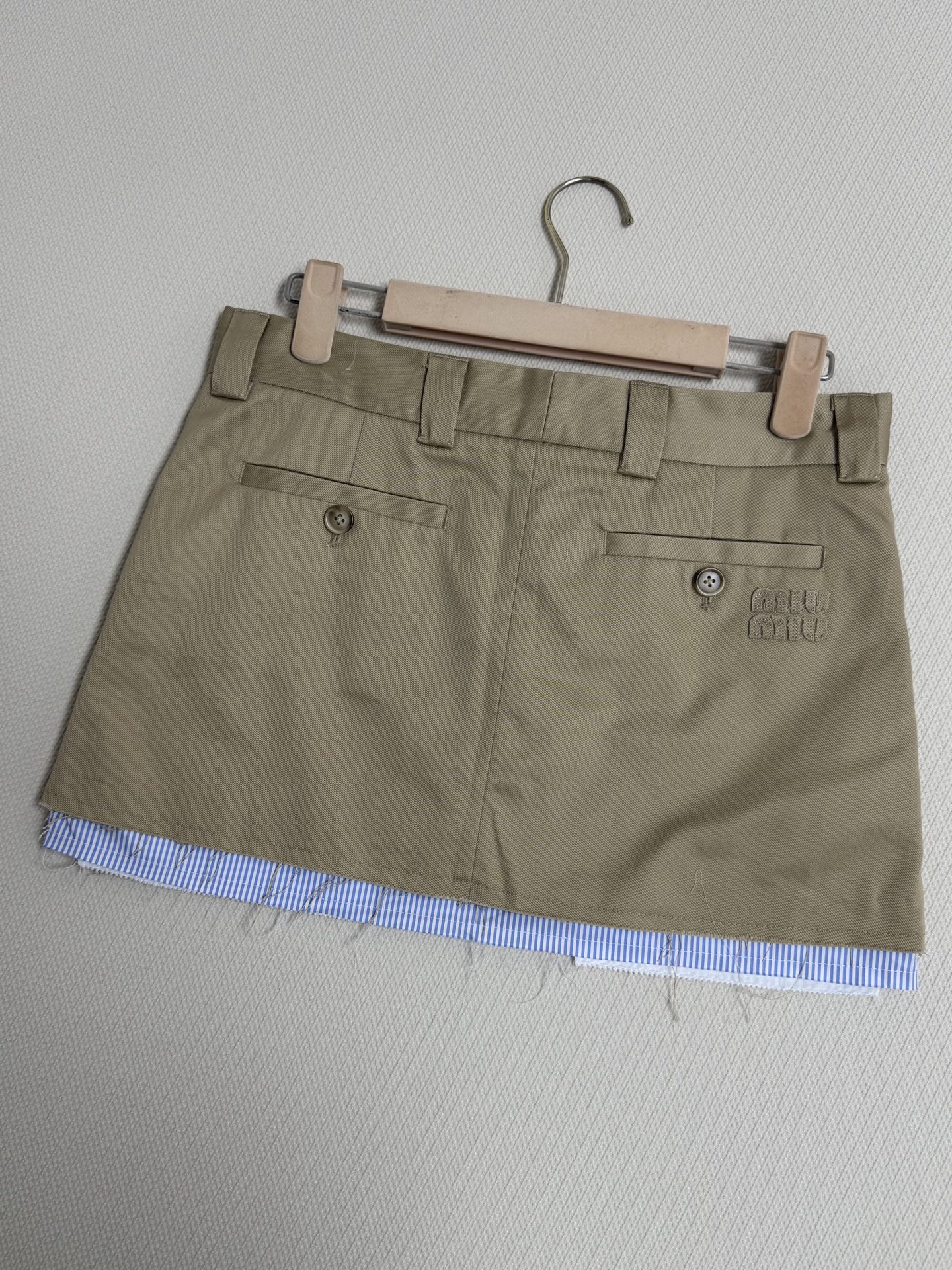 Miu* 26Ss早春新款 卡其色迷你半裙丨⚠独家yb开发！顶级高版出品！以撞色毛边设计重塑学院风。蓝白