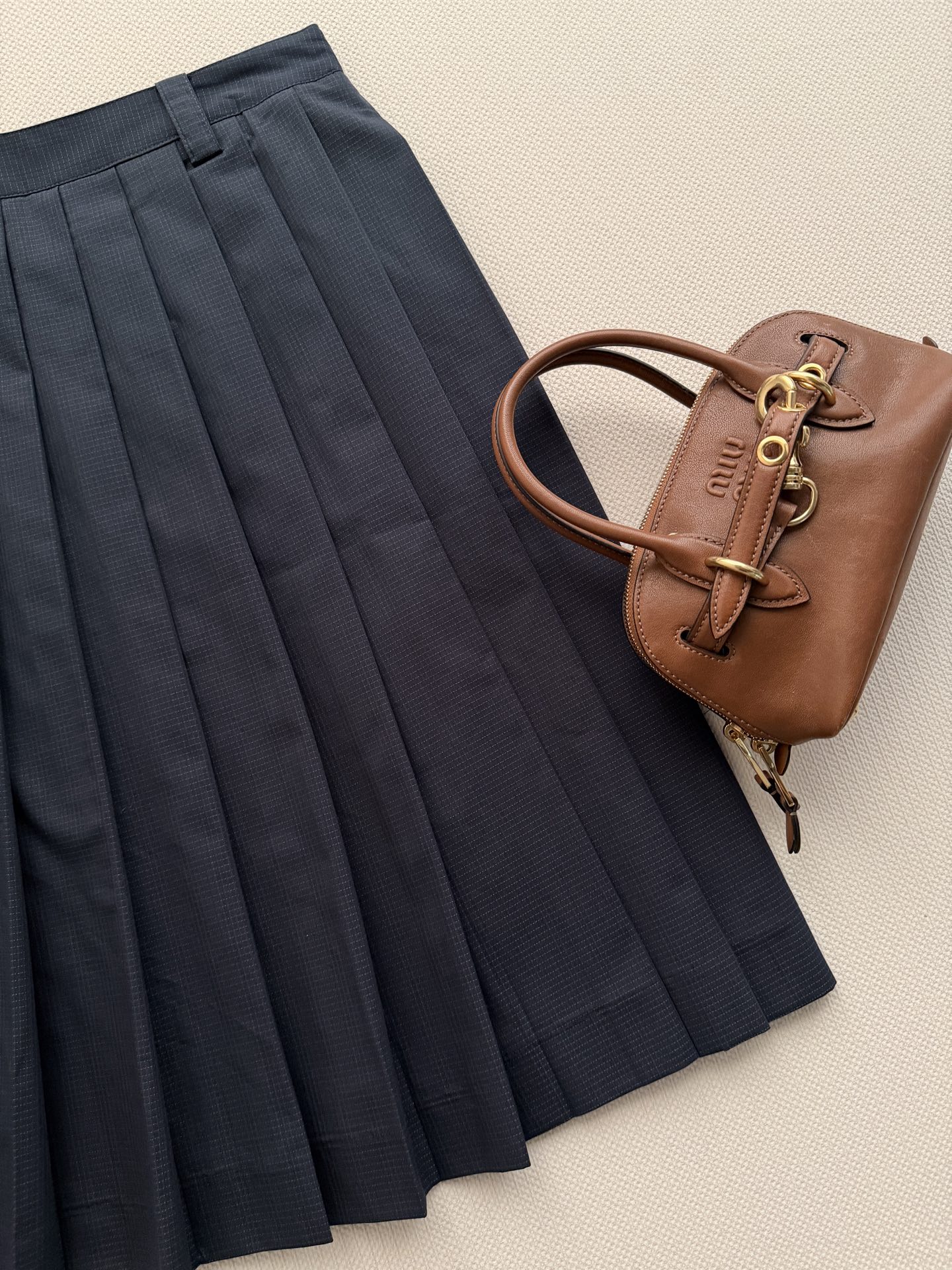 miumi*🆕 这款精致的褶皱半身裙采用棉质防撕裂面料制成，轻盈的技术质感中流露运动风格，展现女性化的轮