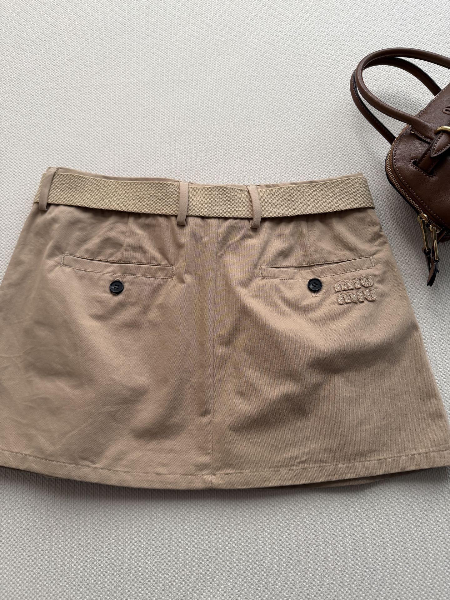 Miumi* 🆕26Ss早春新款 卡其色迷你半裙丨⚠独家yb开发！顶级高版出品！设计重塑学院风。搭配腰带