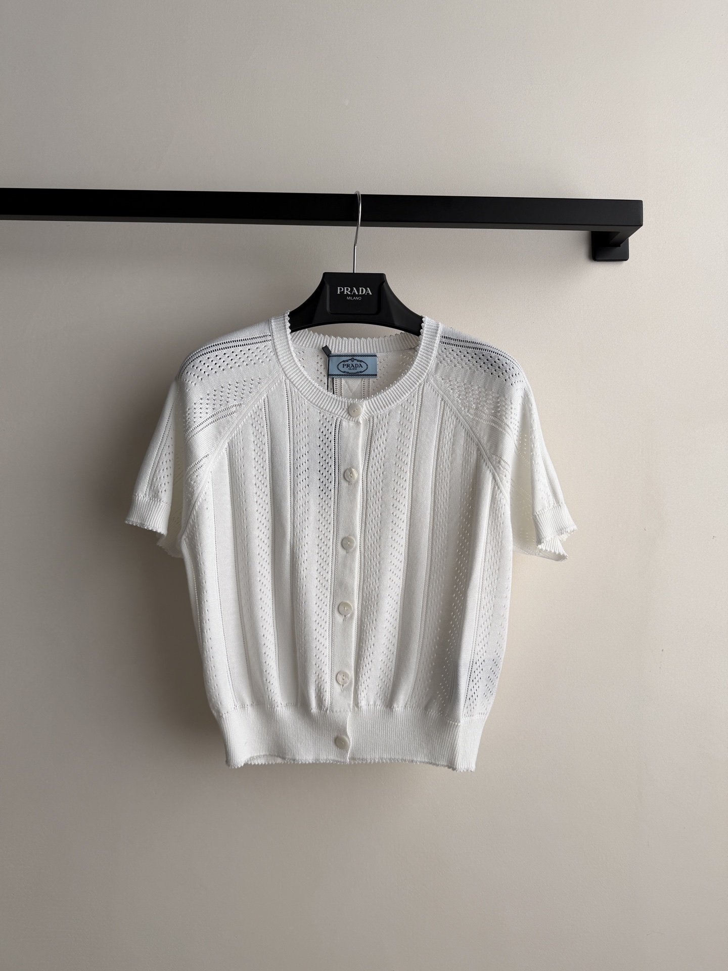 Prada🆕26s夏季新款白色针织开衫，采用轻薄透气针织面料，镂空花纹设计超有层次感✨。短袖+圆领+珍珠