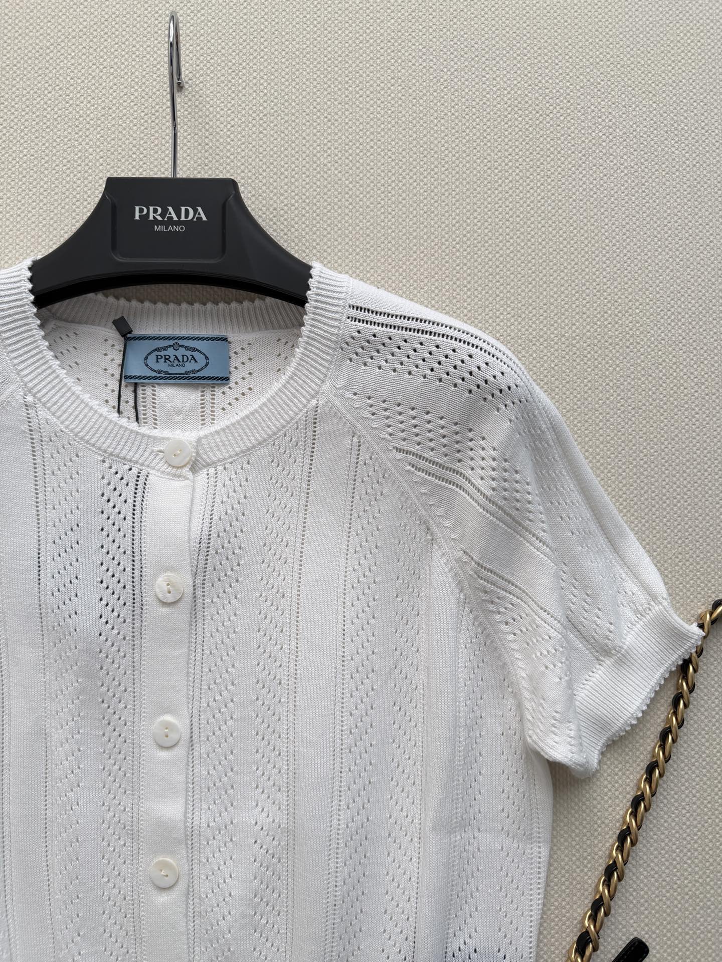 Prada🆕26s夏季新款白色针织开衫，采用轻薄透气针织面料，镂空花纹设计超有层次感✨。短袖+圆领+珍珠