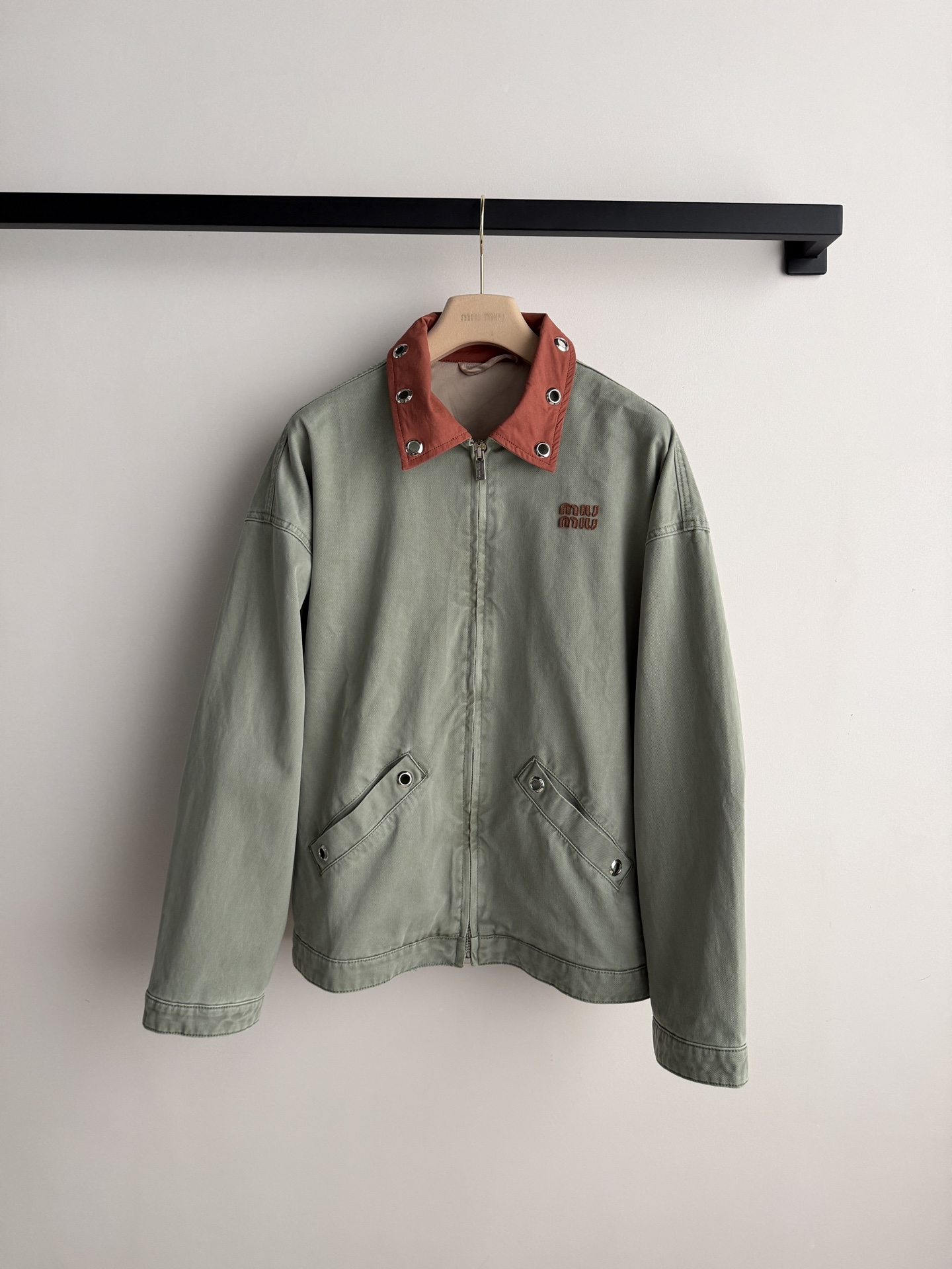 Miu Mi*🆕26春夏秀场新品复古牛仔外套 这件灰绿色夹克以出人意料的橘色金属领子点睛，冷冽与炽烈在领