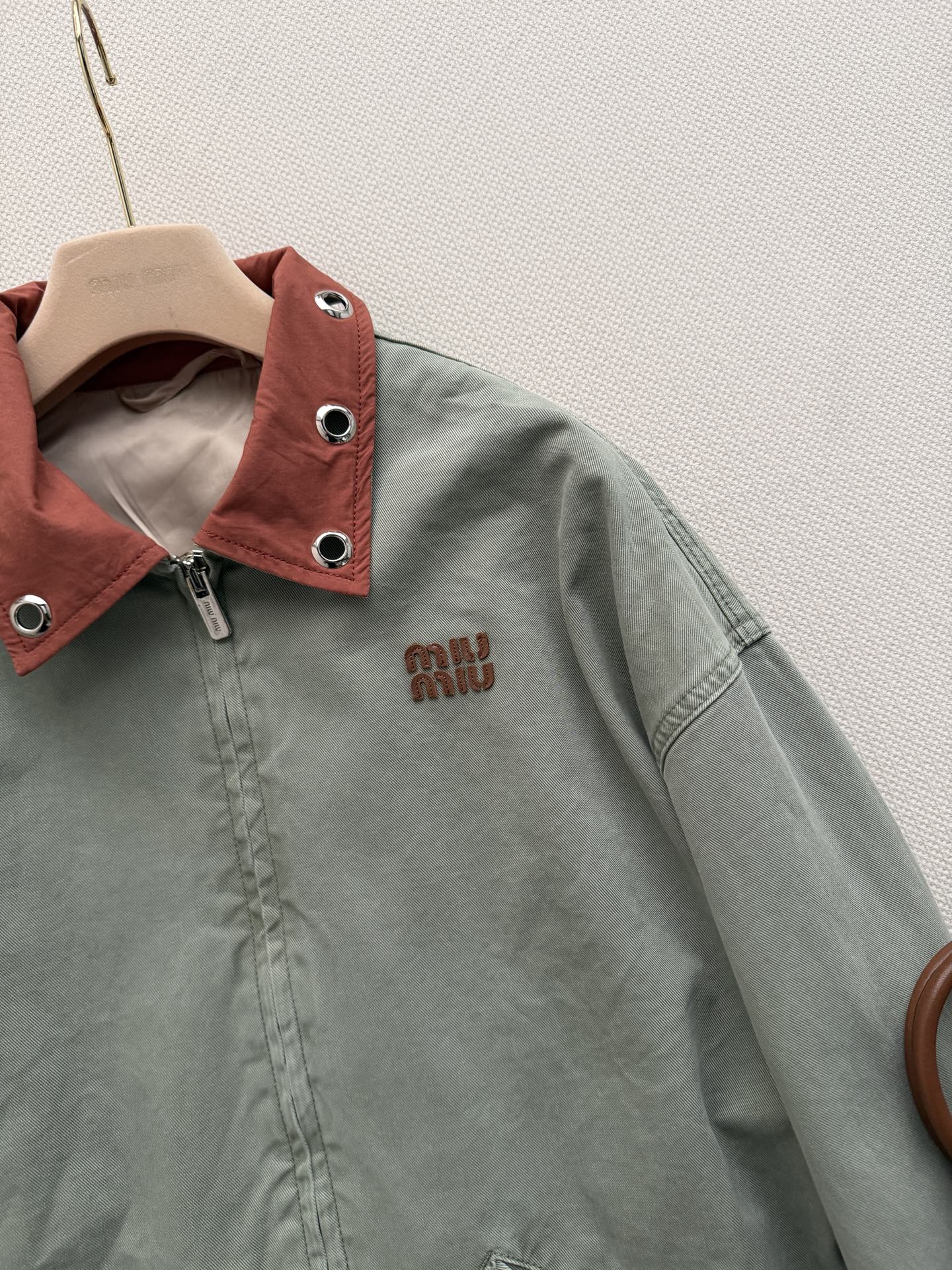 Miu Mi*🆕26春夏秀场新品复古牛仔外套 这件灰绿色夹克以出人意料的橘色金属领子点睛，冷冽与炽烈在领