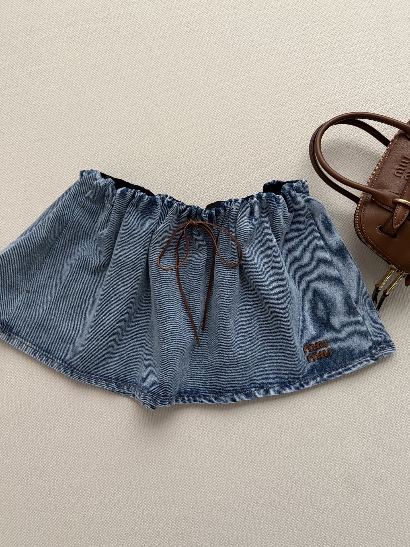 Miumi*🆕26年新款牛仔半裙 皮革抽绳搭配小蝴蝶结，瞬间唤醒少女心，温柔中透着灵动，甜度直接拉满~牛