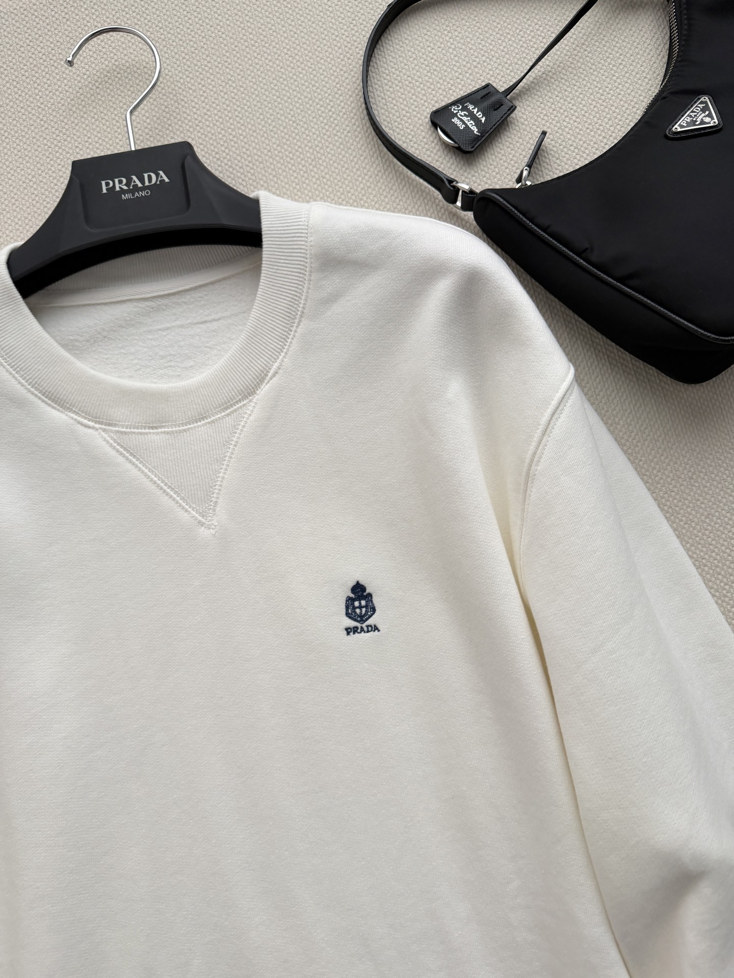 Prad*🆕这款圆领棉质卫衣采用Oversize廓形和宽松版型，刺绣徽标为运动设计增添了精致和经典的韵味