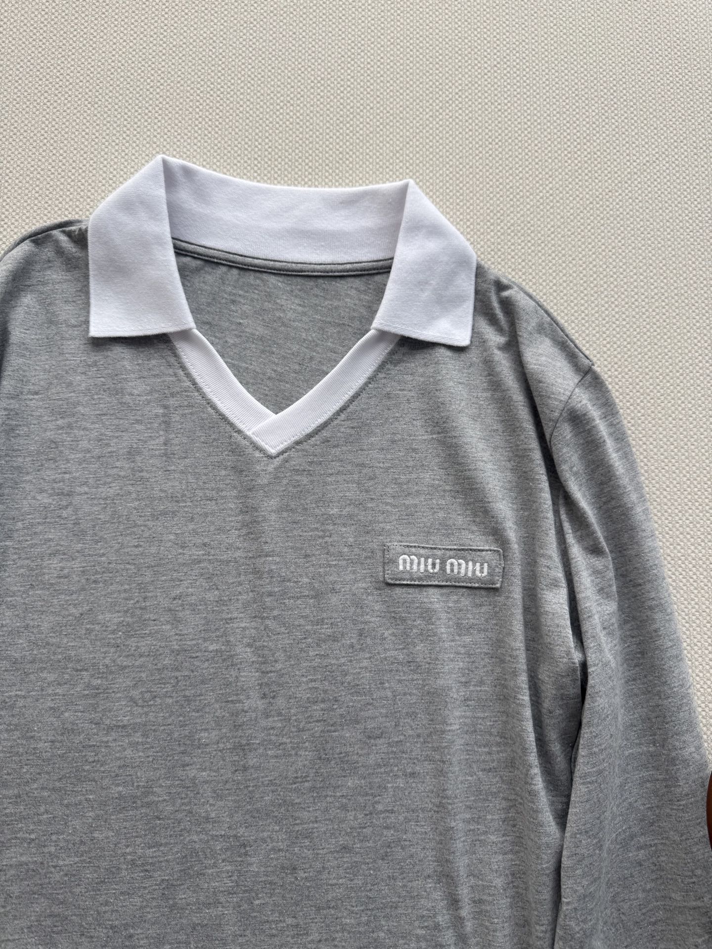 miumi*🆕灰撞白POLO领长袖，复刻学院风轻奢调性。撞色翻领与袖口勾勒层次，V型领口修饰脖颈线条，胸