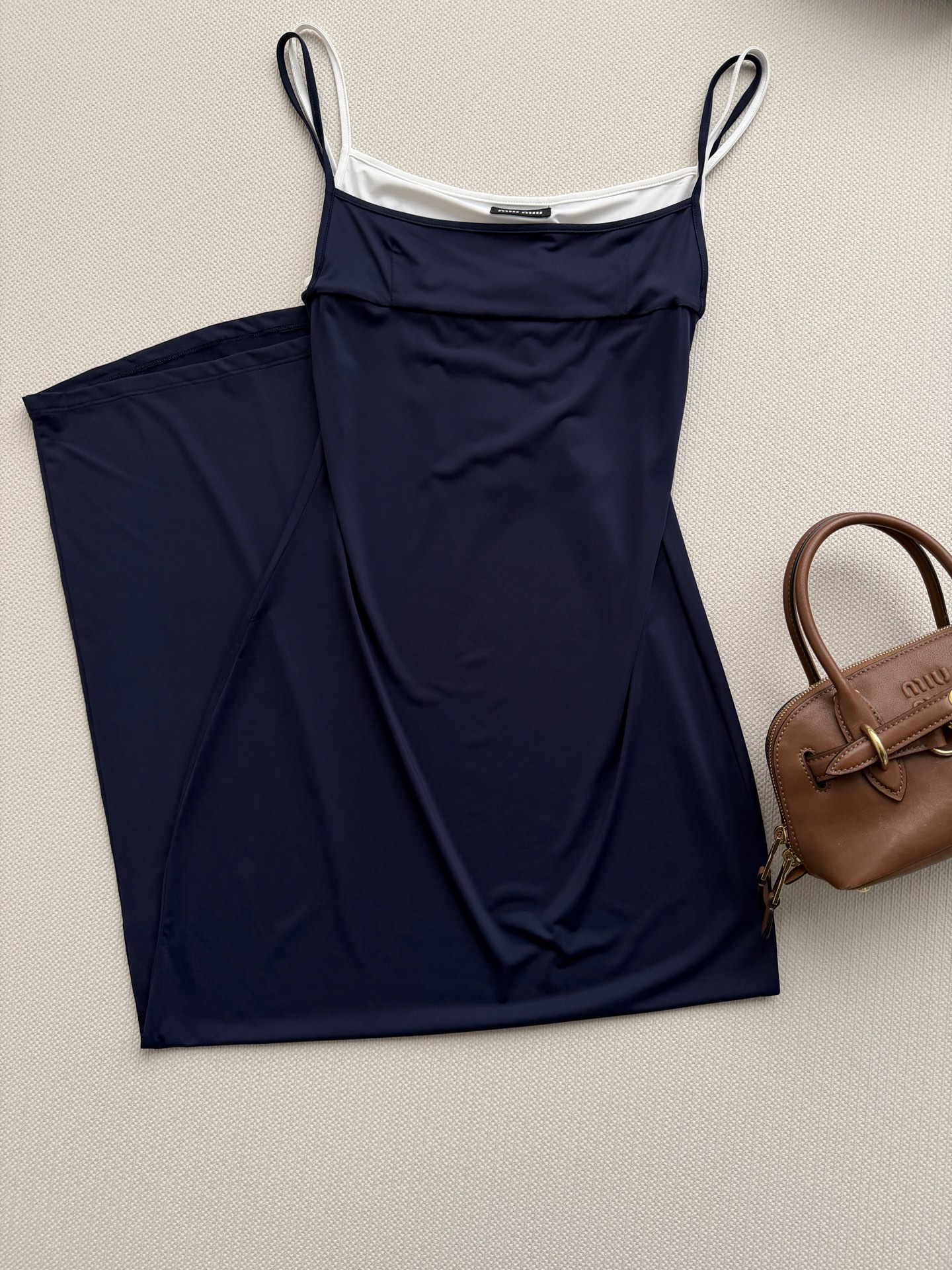 Miu Mi*🆕26新款假两件荡领吊带长裙，以深邃的藏青色为主调，搭配内层的米白色打底，营造出极具层次感