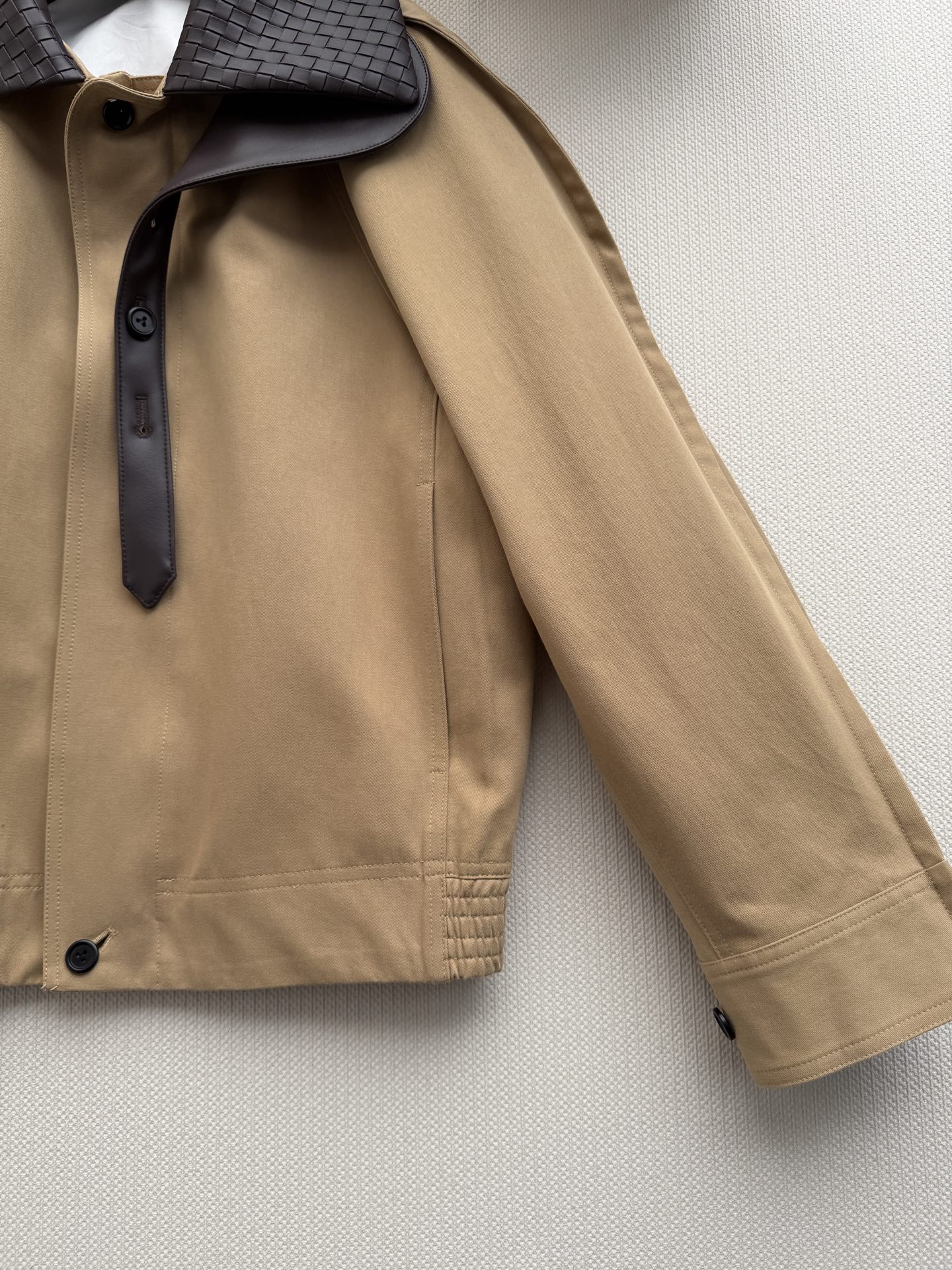 Bottega Venet*🆕夹克采用经典卡其色工装面料，搭配深色编织羊皮领，低调又有辨识度。短款落肩设计+单排暗扣，蝙