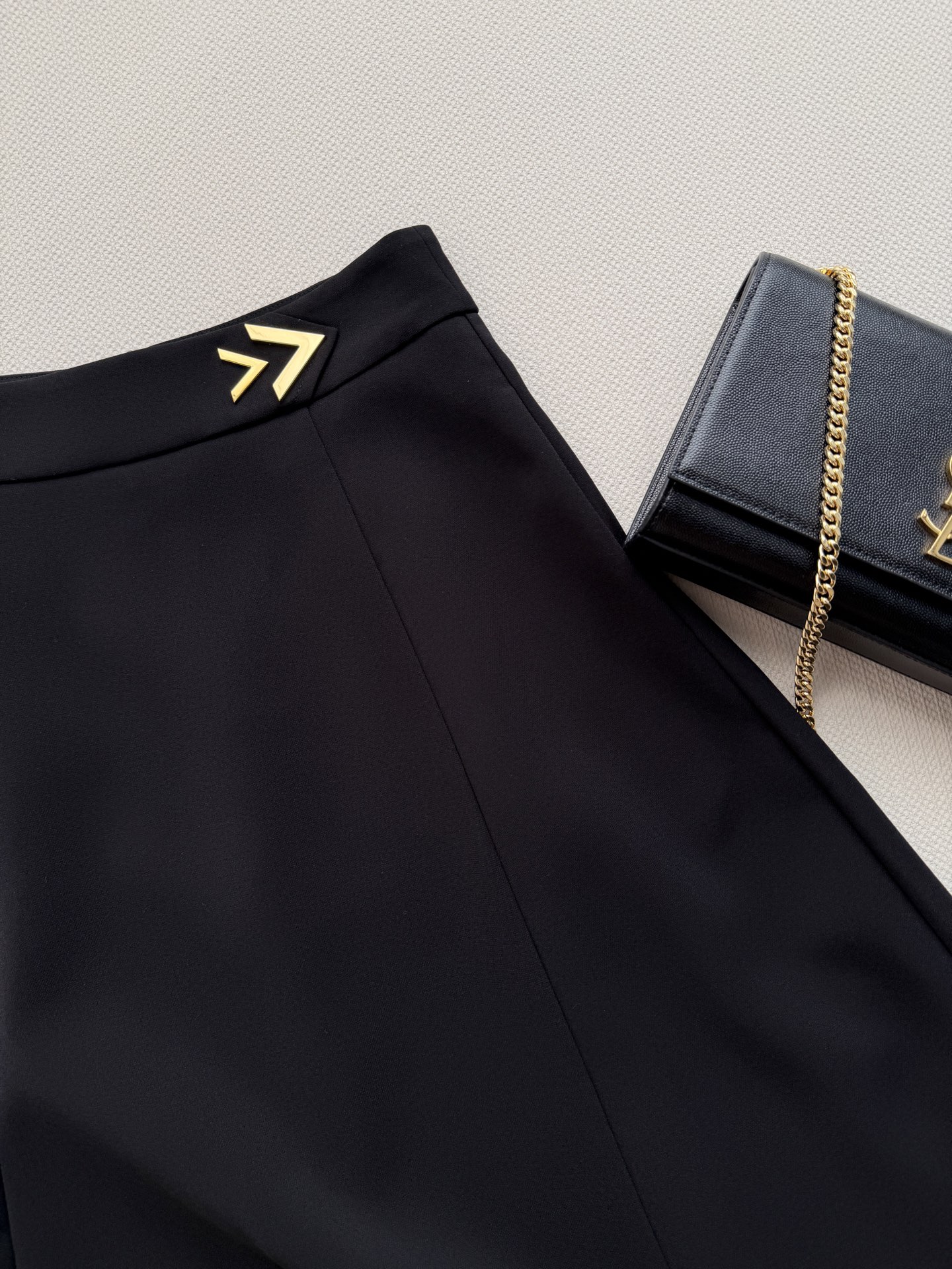 Valentin*🆕黑色高腰A字半身裙，垂坠感面料+金属箭头装饰，简约又有细节感✨。高腰A字版型修饰腰线，拉长腿部比例，