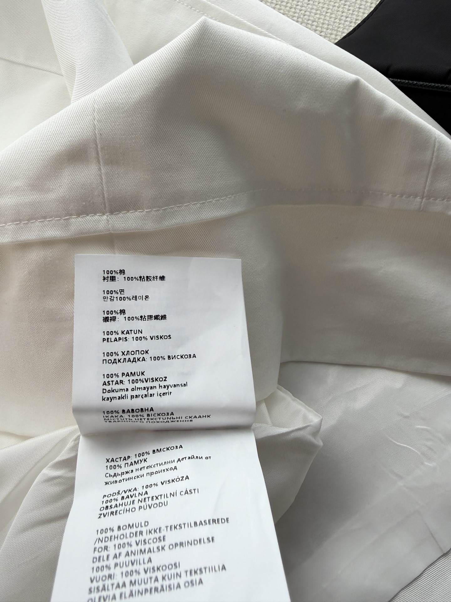Prad*🆕纯白无袖衬衫连衣裙选用挺括透气的优质面料，前襟半开金属拉链设计利落亮眼，胸口品牌刺绣低调凸显辨识度。宽松直筒