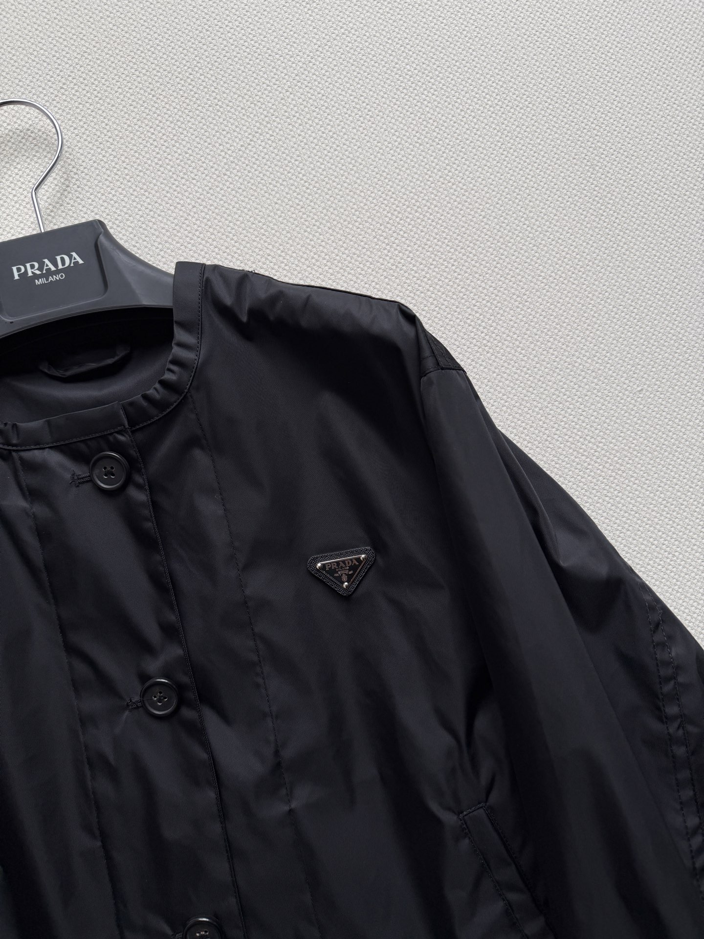 Prad*🆕 26早秋系列的圆领再生尼龙夹克​​，胸前有经典的三角珐琅徽标，下摆带抽绳收口设计，整体版型偏短款、微宽松。