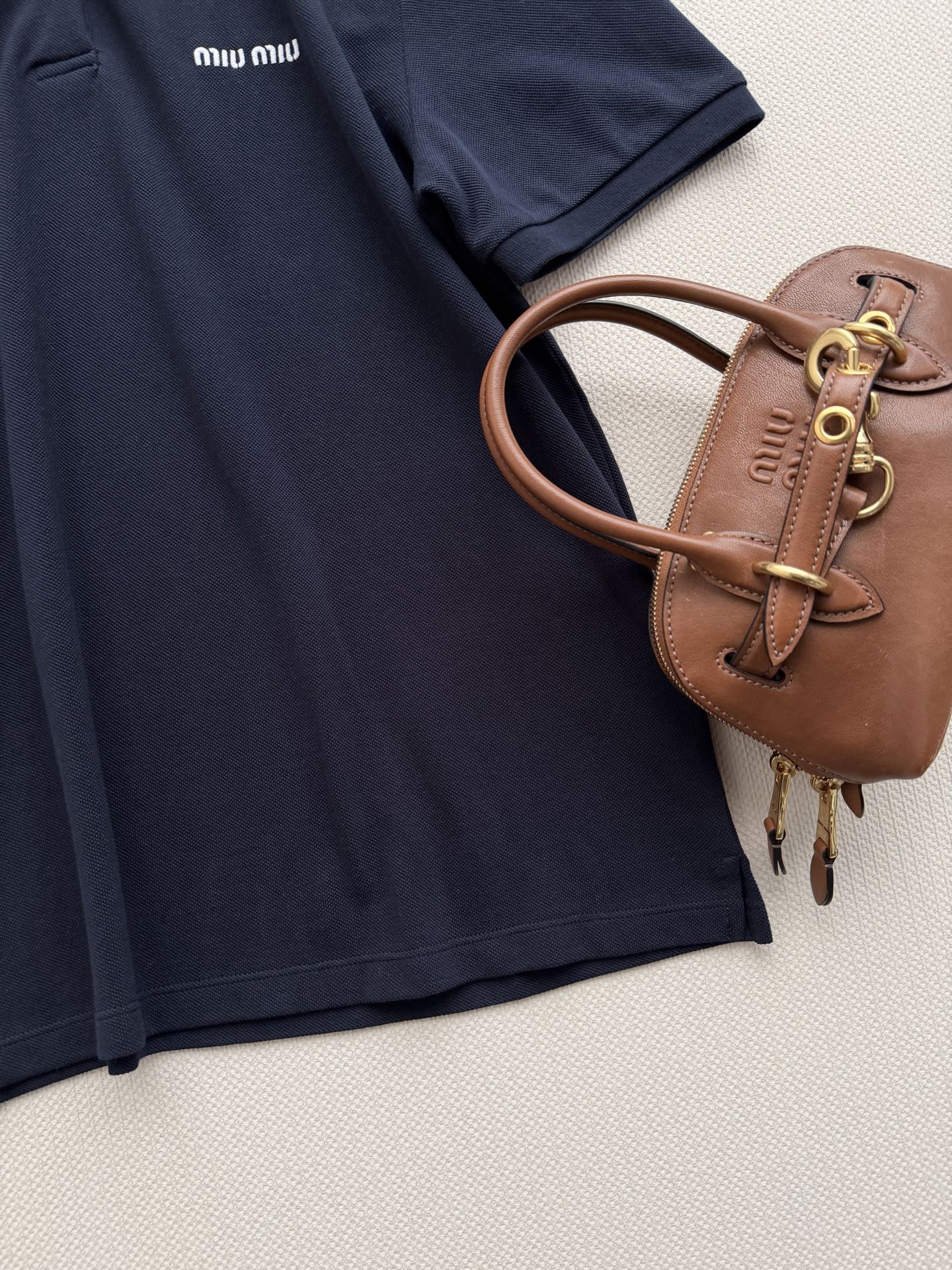 Miu Mi*🆕26新款藏青色 Polo 衫简直是甜酷女孩的本命单品呀✨！经典藏青色衣身采用 100% 纯棉材质，透气又
